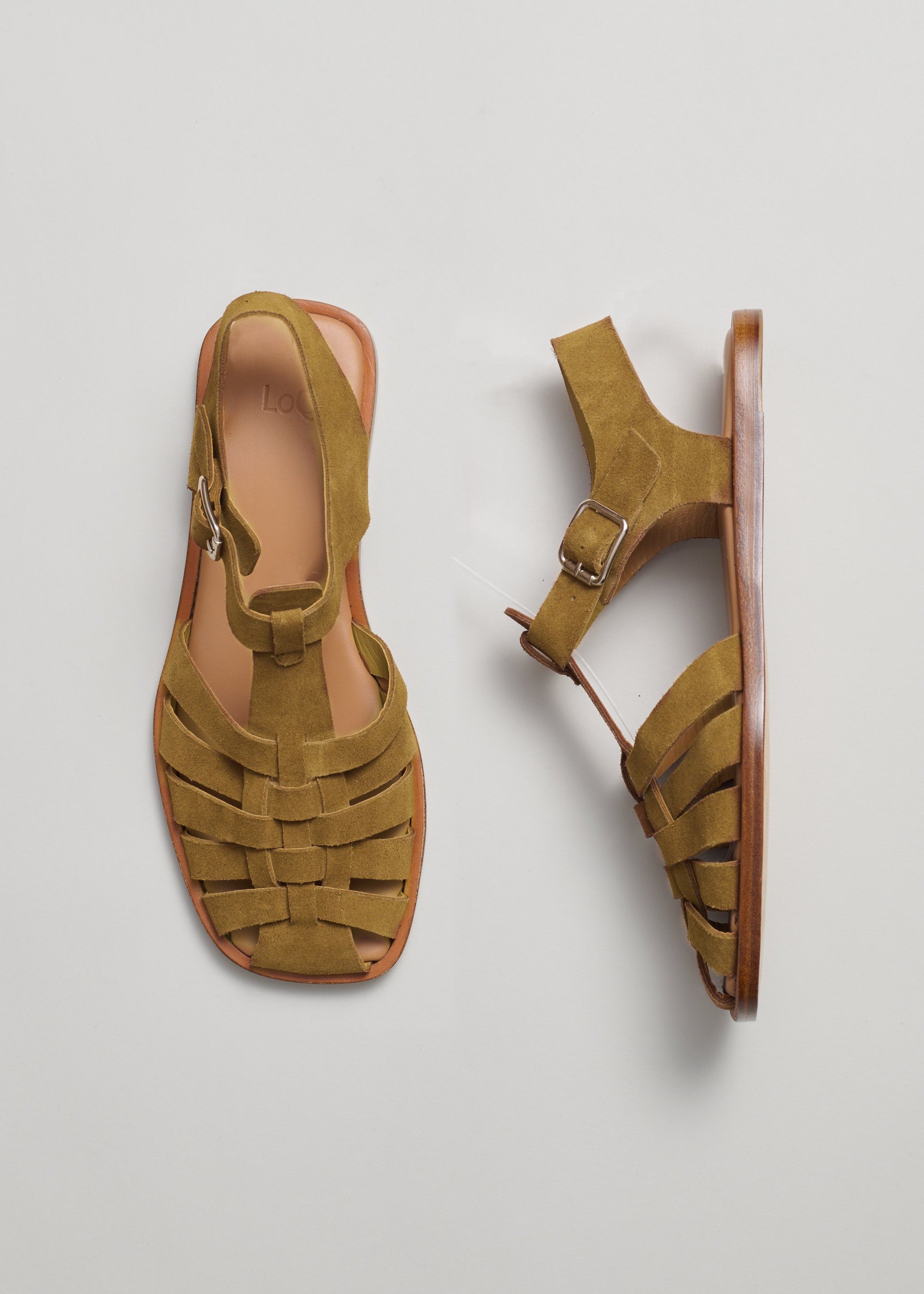 Pair of cumin-colored suede sandals on a light gray background