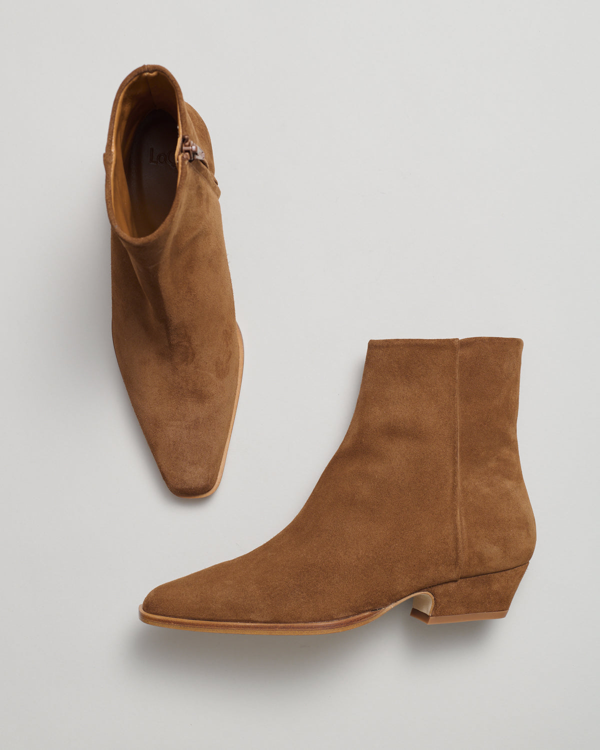 A pair of suede leather western style ankle boots with pointed toes and low cuban heel.