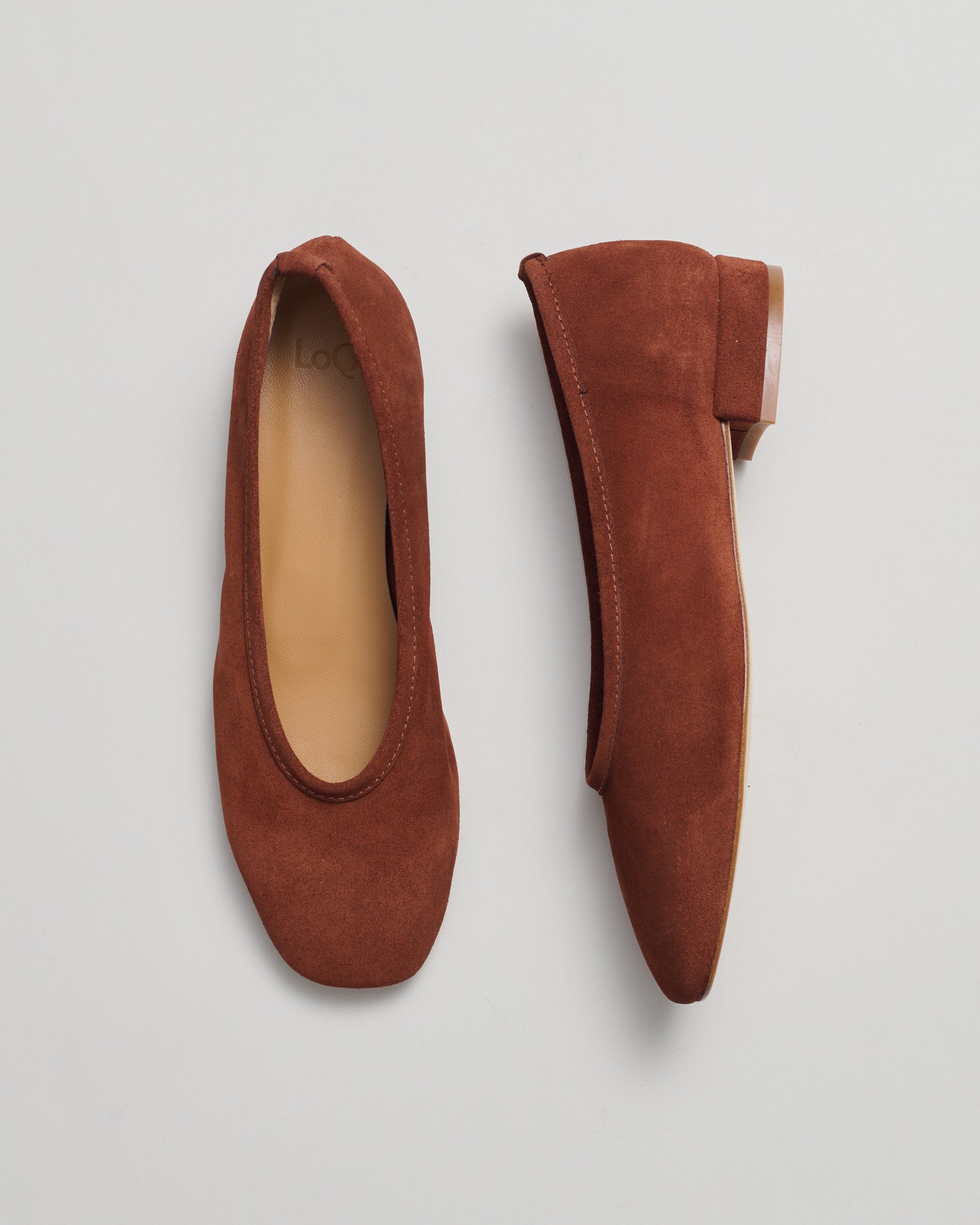 A pair of brown suede ballet flats shown from two angles (top-down and side-profile) on a light gray background.