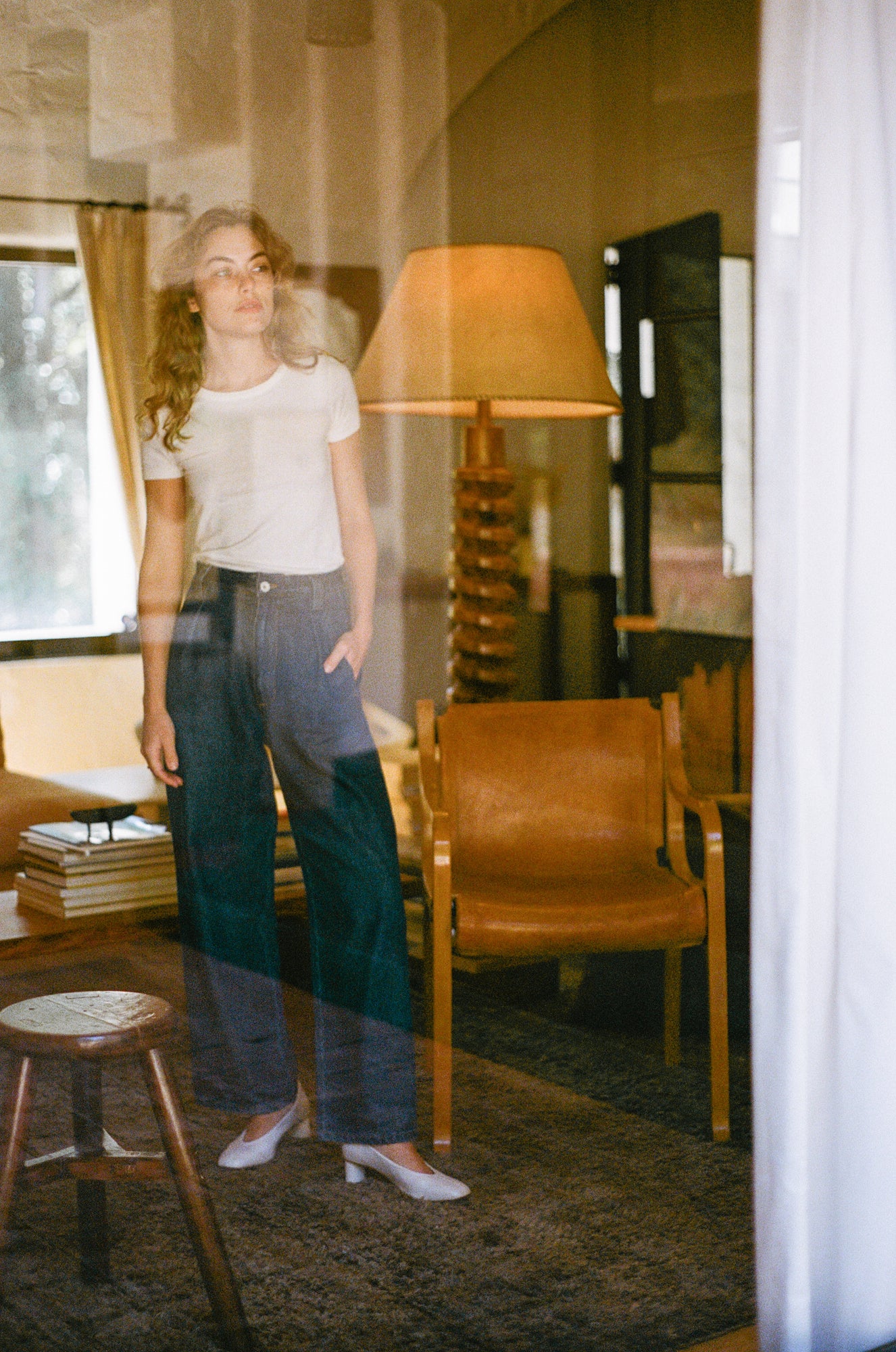 Model wears an off-white leather pump with sculptural oval heel.