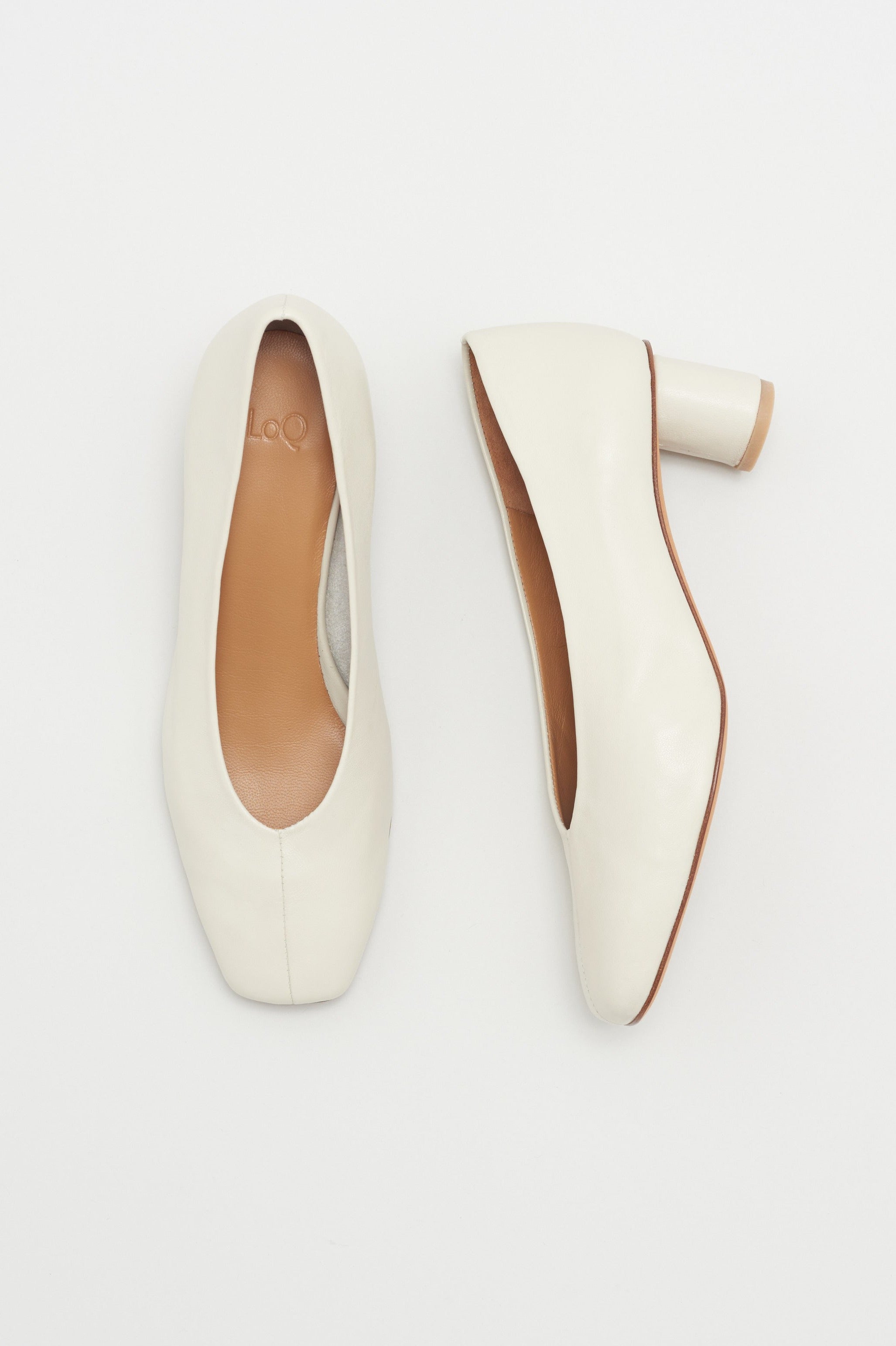 Off white leather pump with center seam and oval shaped heel.