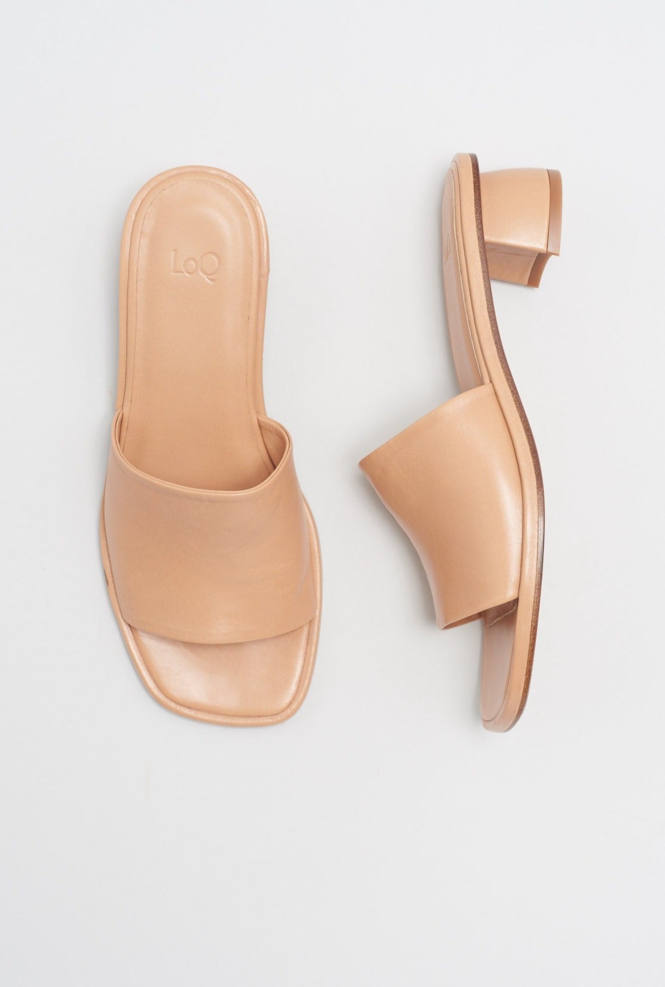 Light beige leather slide sandal with curved short heel.