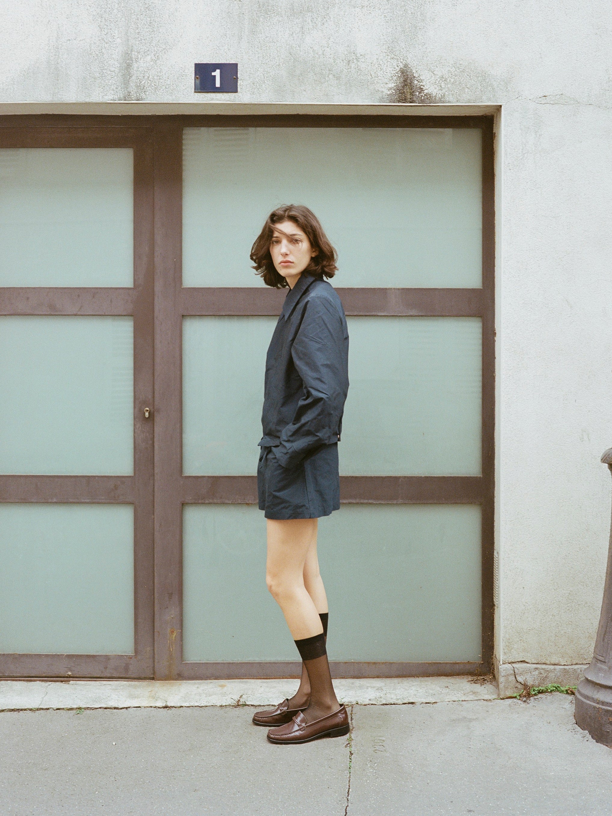 Model wears chocolate brown leather loafer.