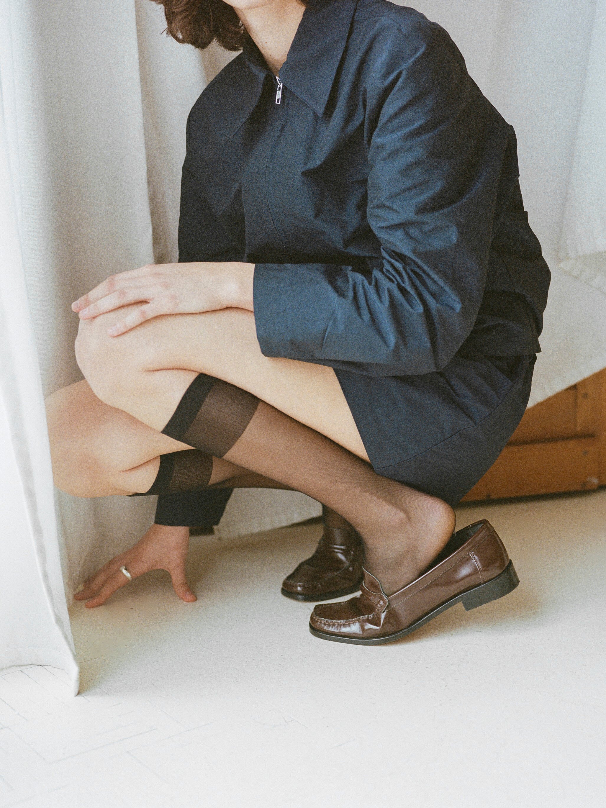 Model wears chocolate brown leather loafer.