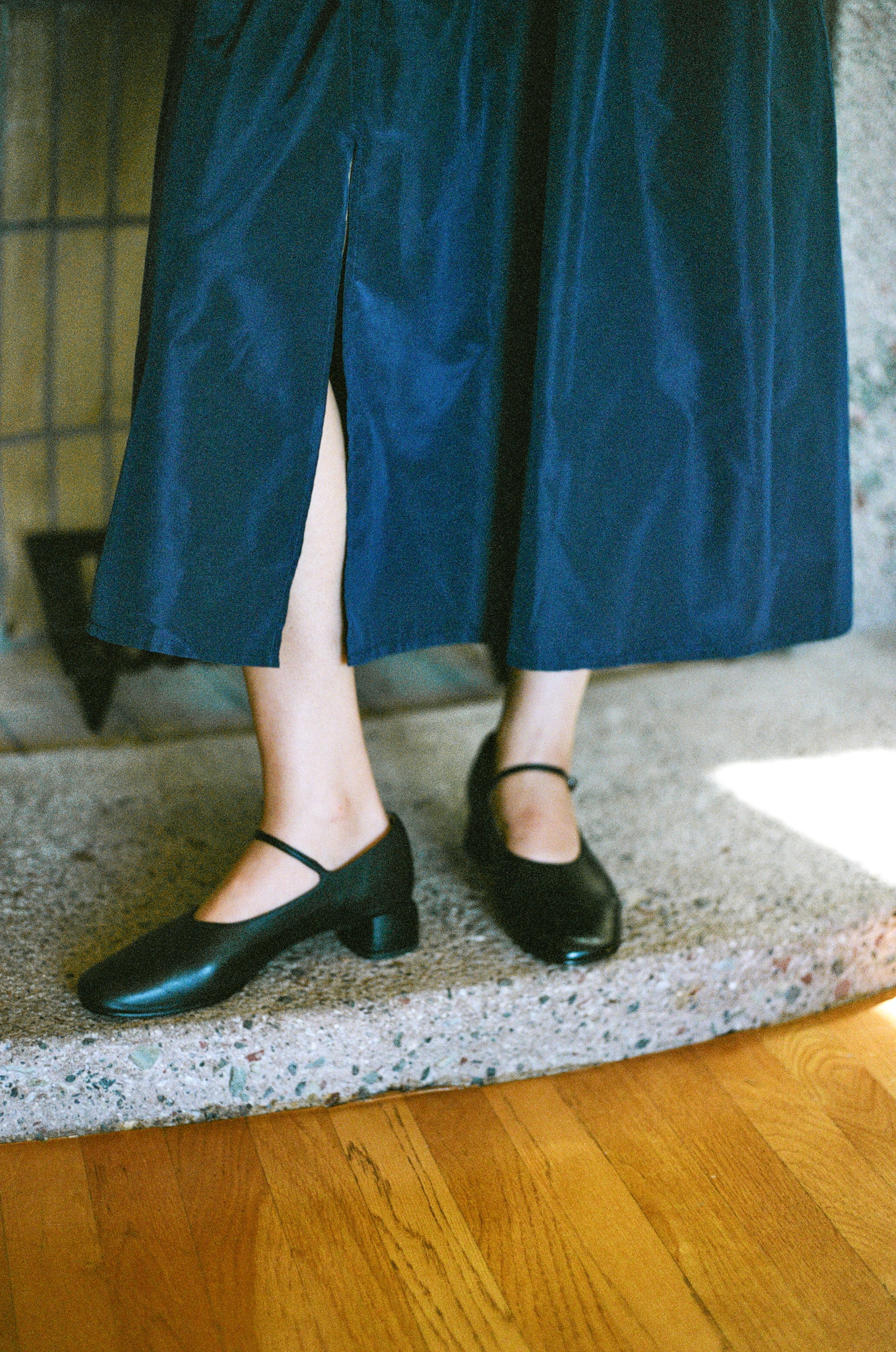 Model wears modern Mary Jane featuring a classic silver buckle with an updated round heel in black leather. Round toe and 1" covered heel.