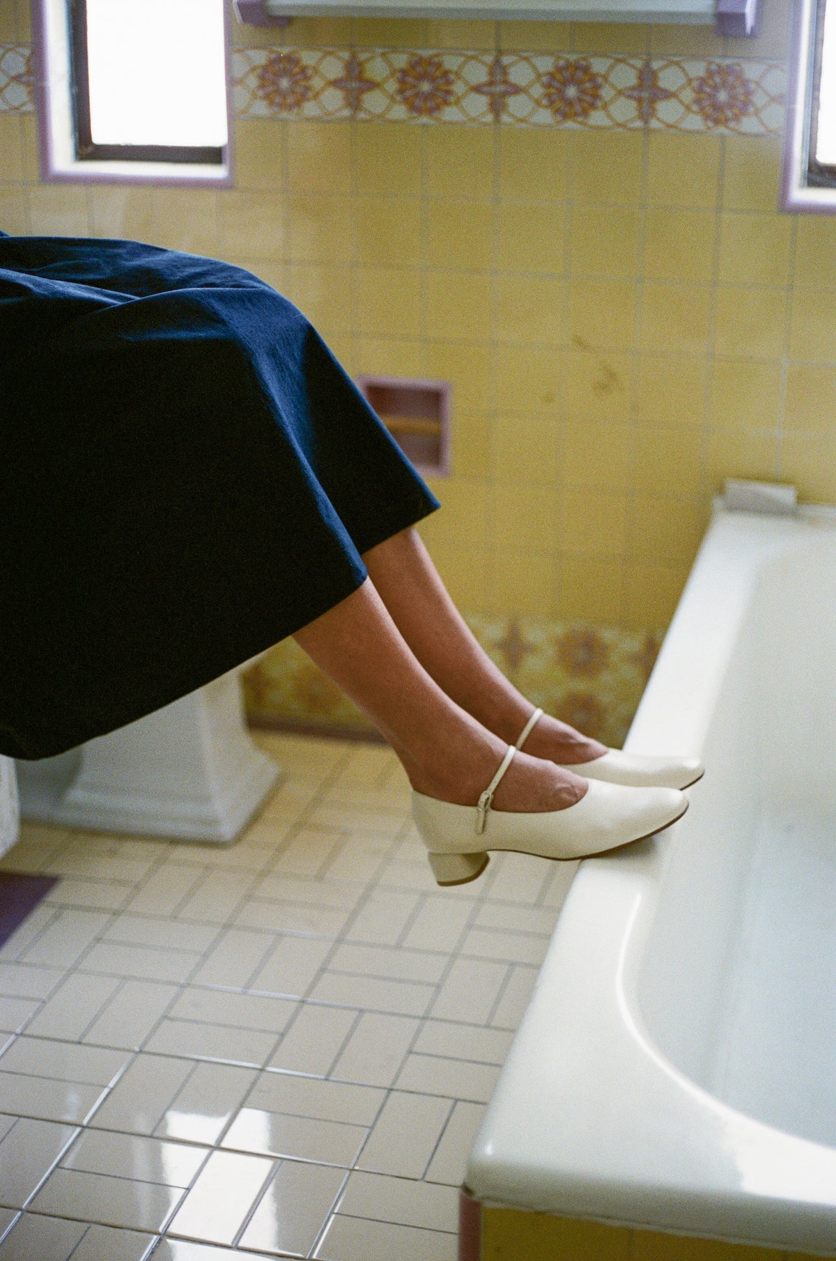 Model wears modern Mary Jane featuring a classic silver buckle with an updated round heel in an off white leather. Round toe and 1" covered heel.