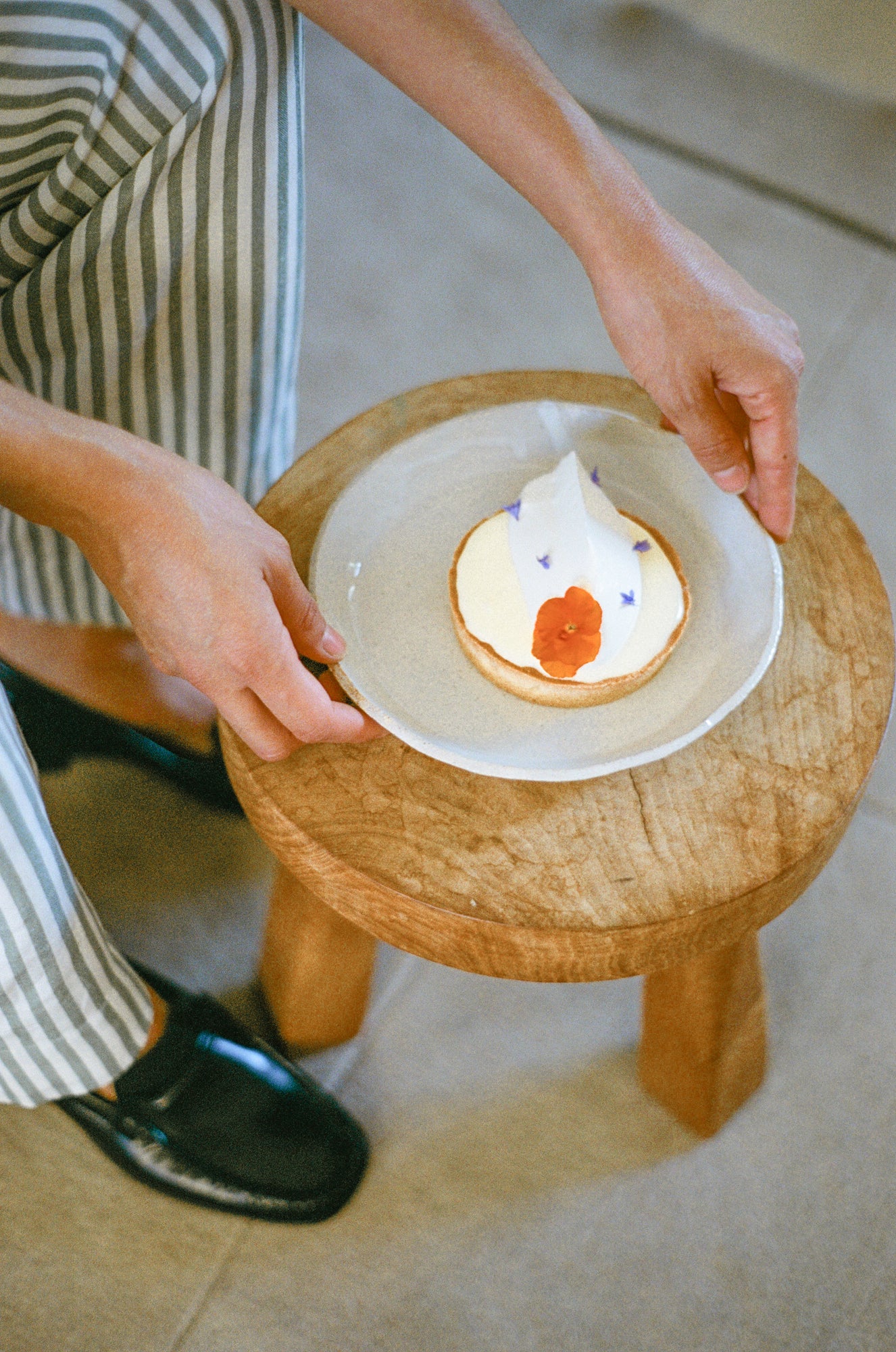 Model holds white ceramic deep plate.