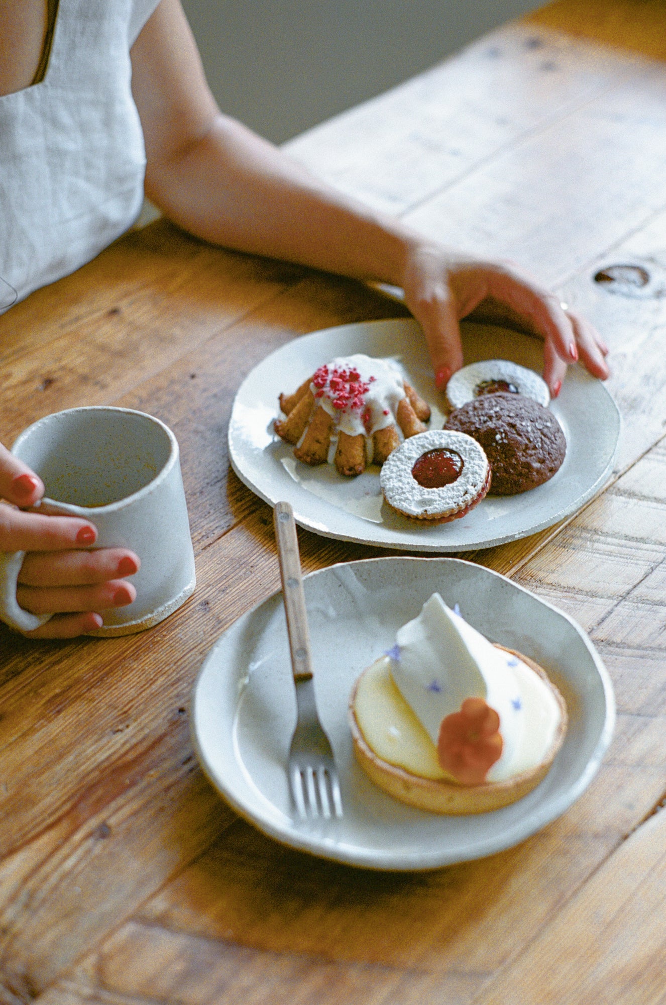 Model poses with white ceramic plates and mug.