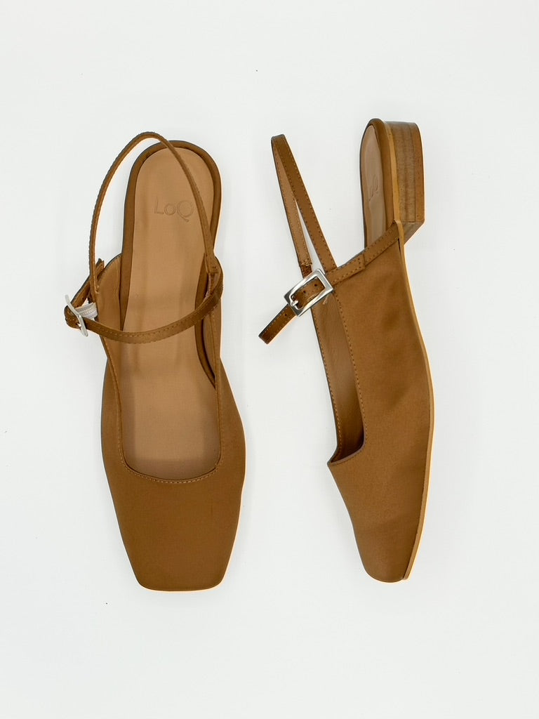 Pair of satin brown slingback shoes on a white background