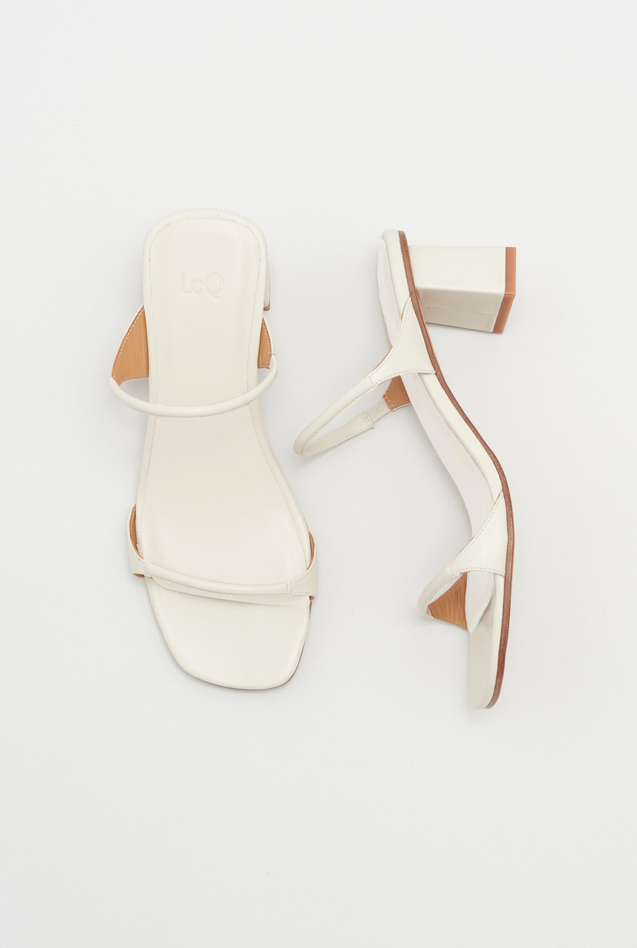 Off white colored leather sandal featuring two thin straps and square block heel.