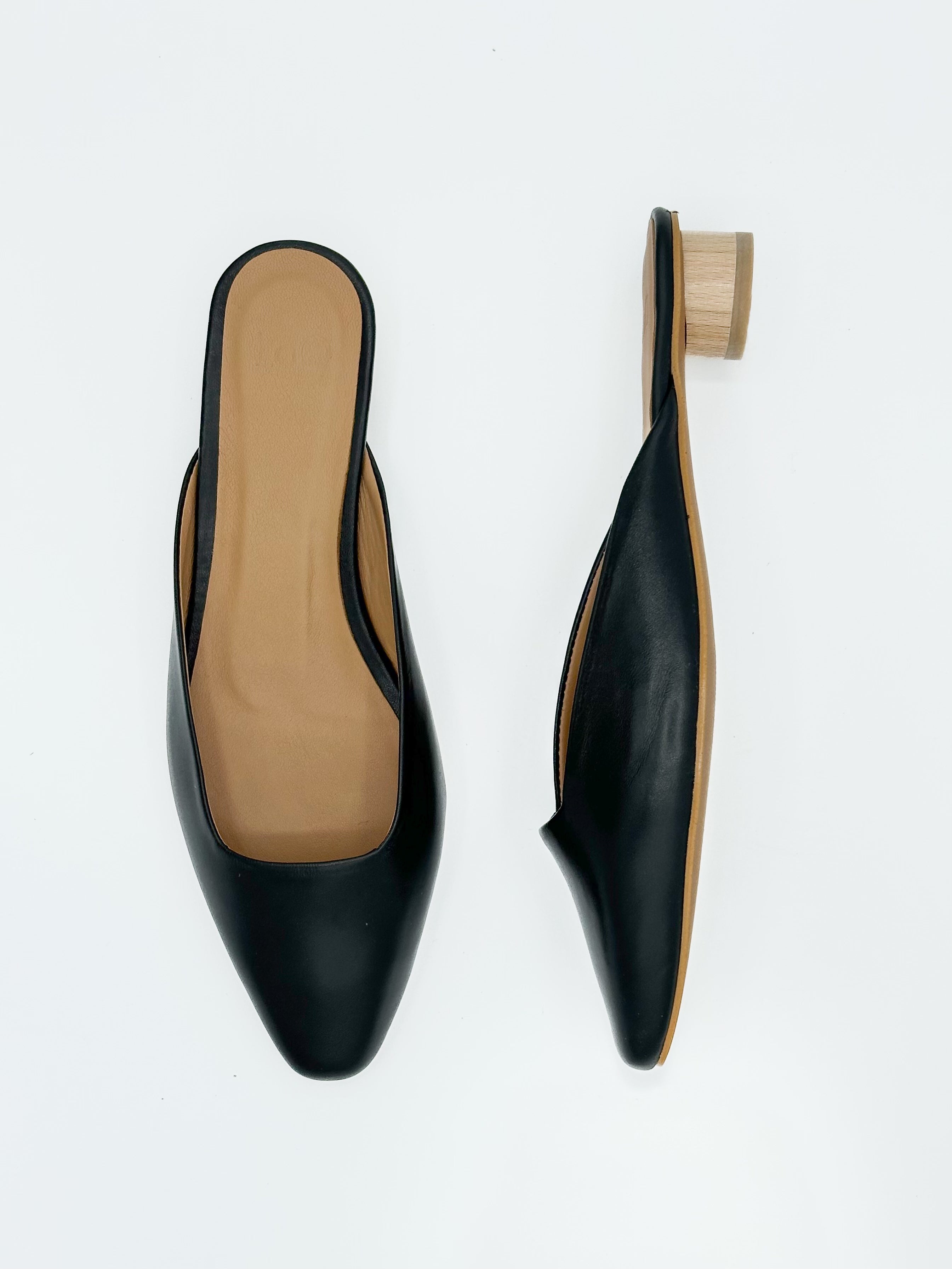 Black shoe with wooden sole on a white background