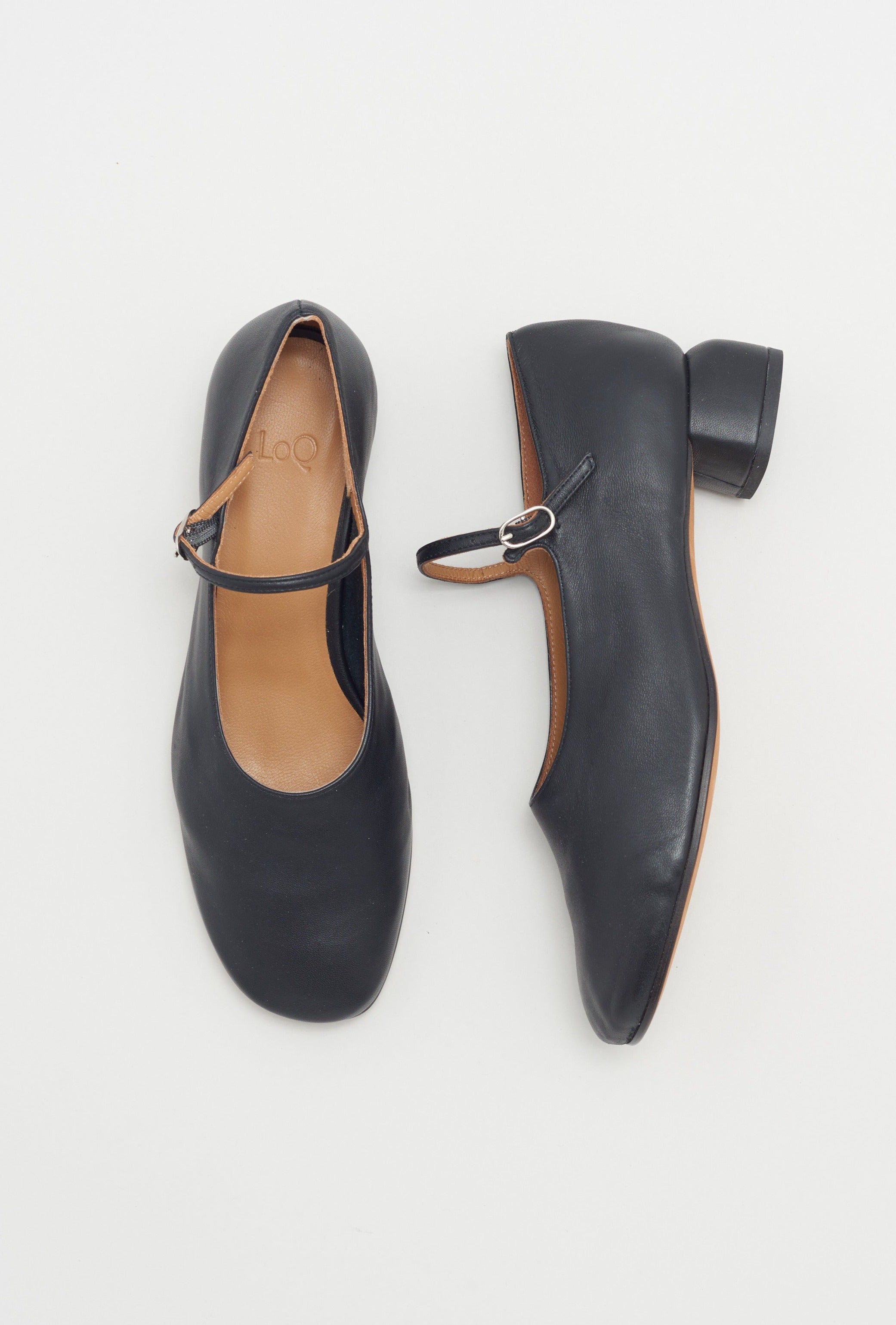 Modern Mary Jane featuring a classic silver buckle with an updated round heel in black leather. Round toe and 1" covered heel.