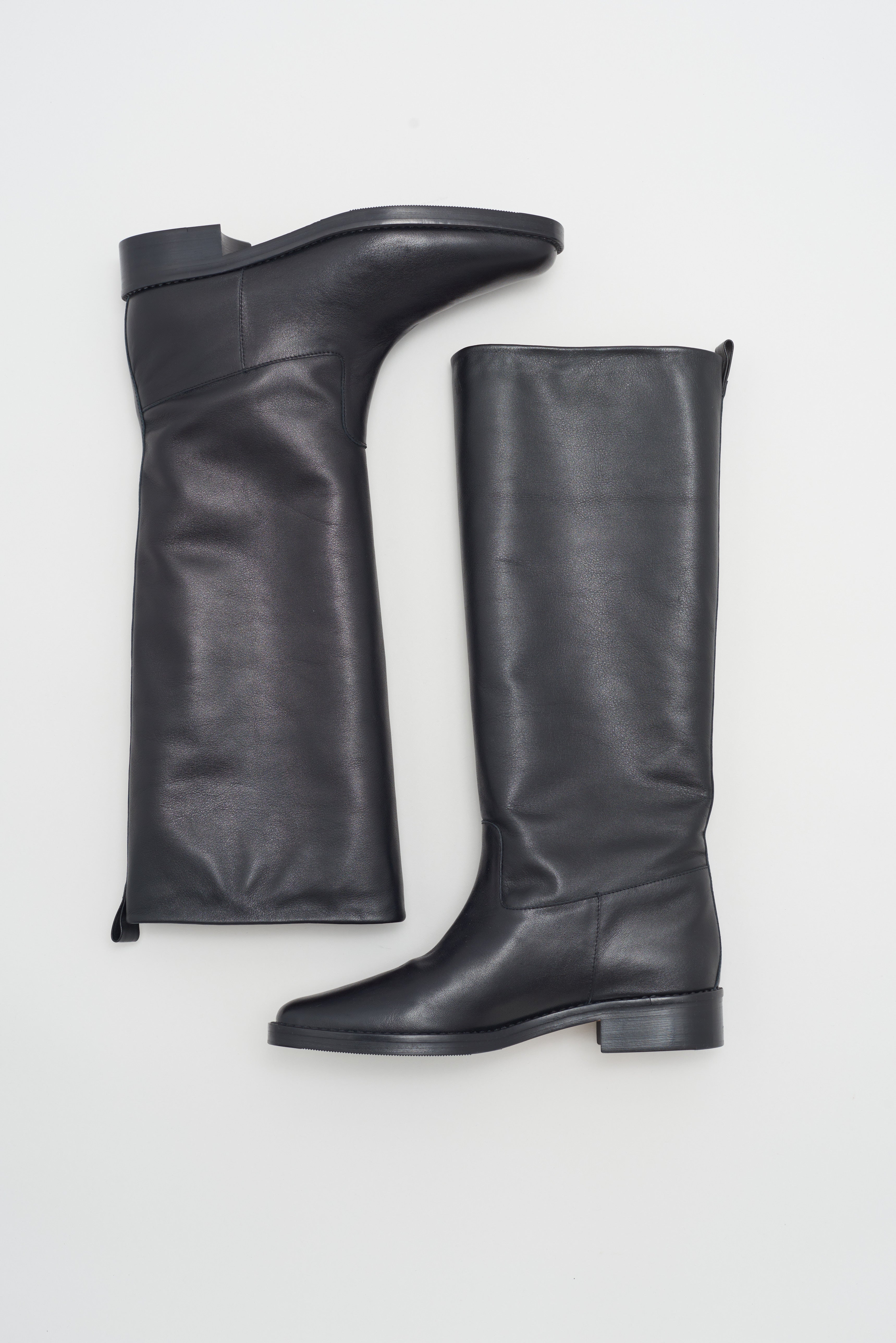 Tall riding boot with short heel in smooth black leather.