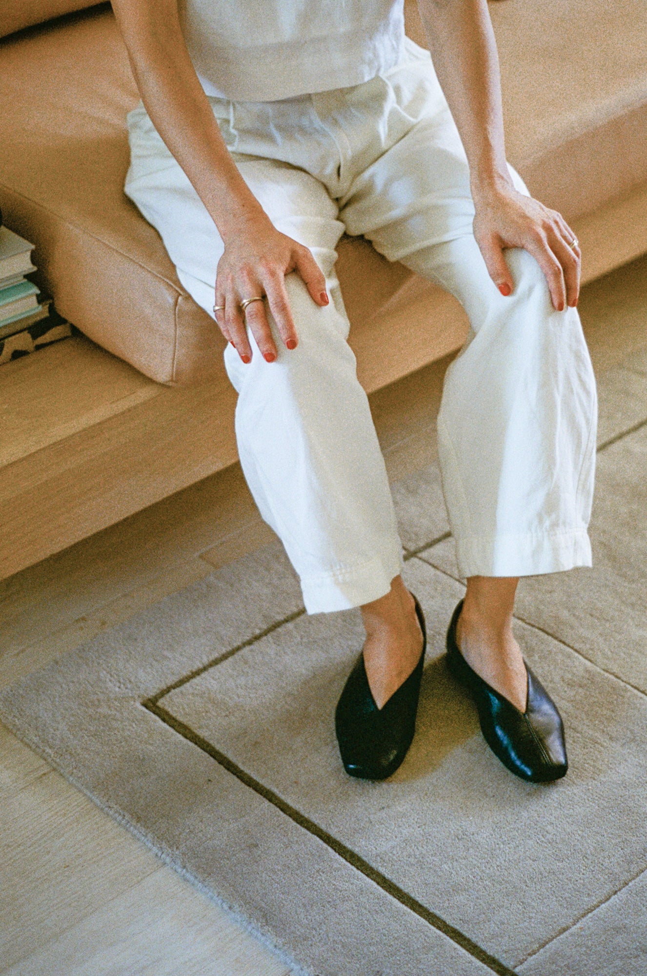 Model wears black leather flats with a tulip shaped upper.