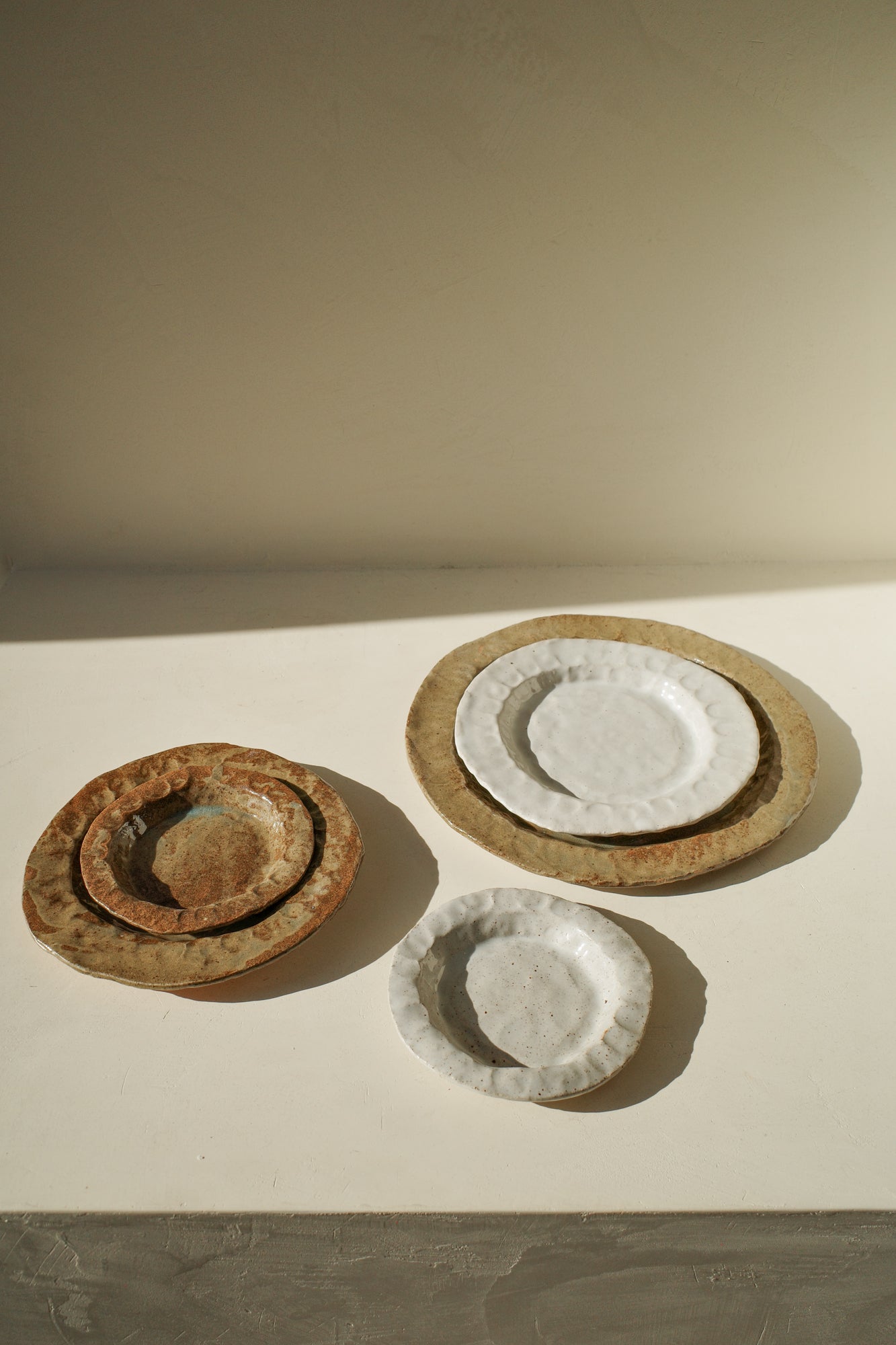 Handmade ceramic plates in varying sizes and glazes.