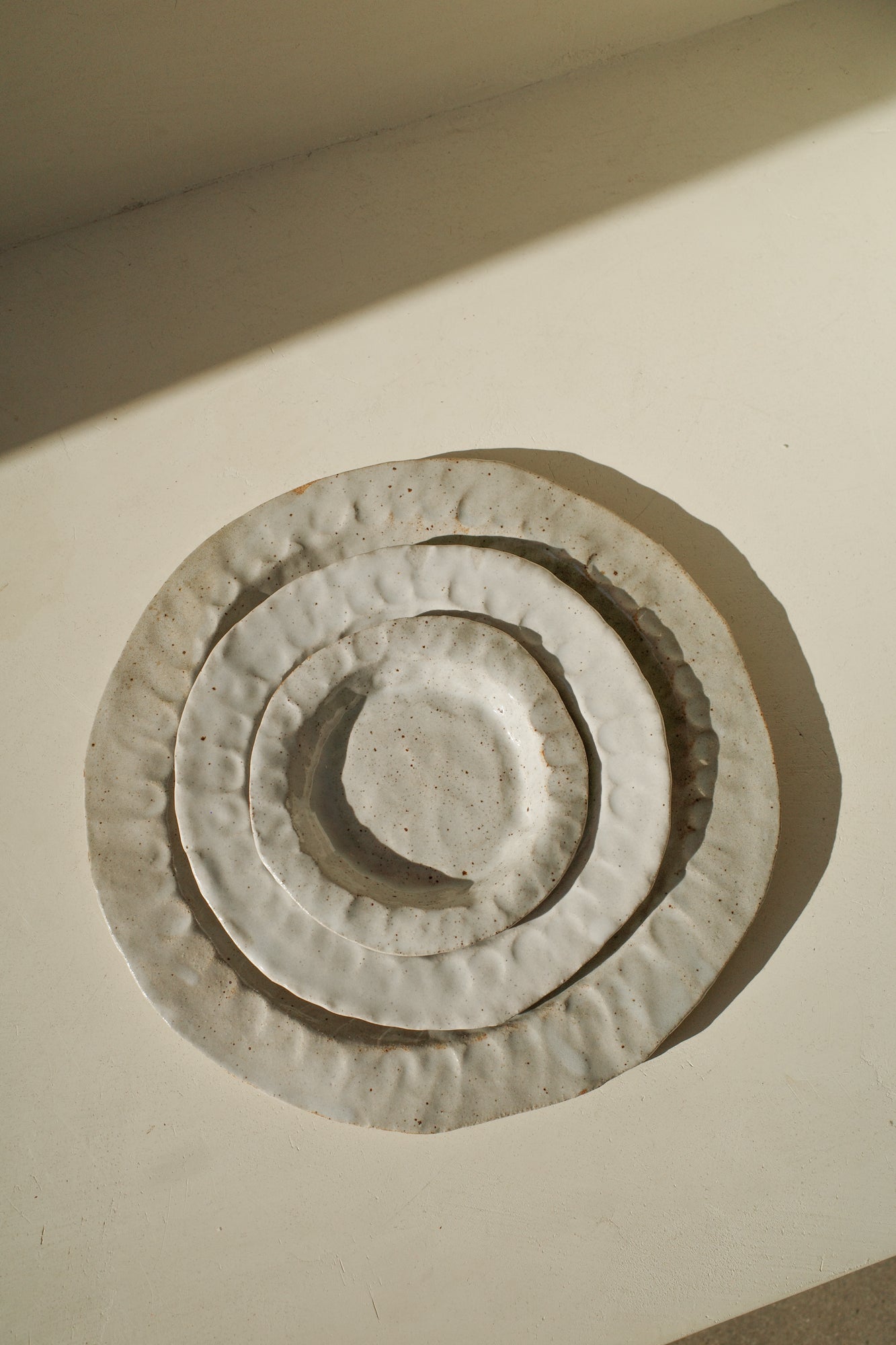Handmade ceramic plates in varying sizes.