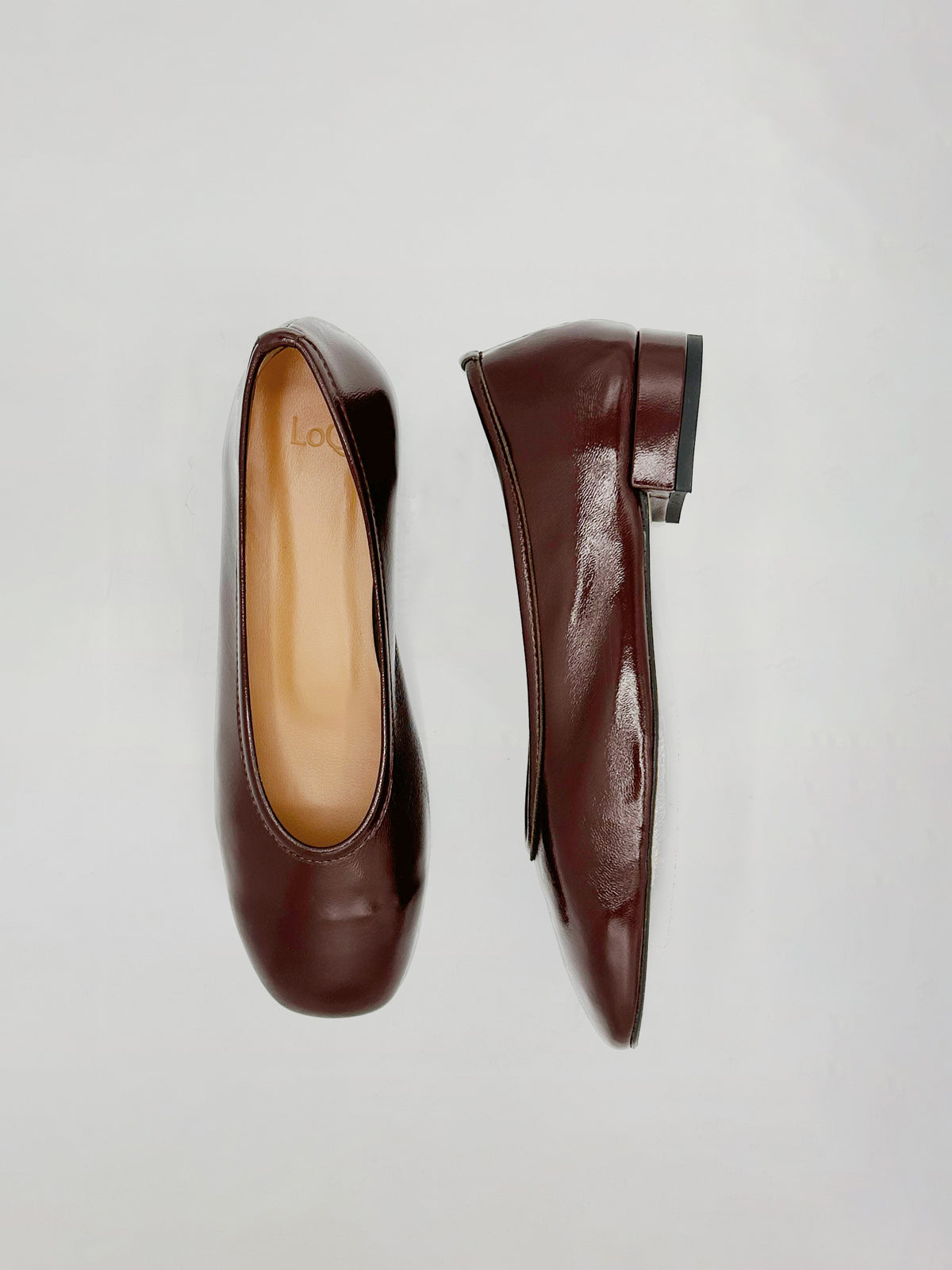 A pair of dark burgundy leather ballet flats shown from two angles (top view and side profile) on a light gray background.