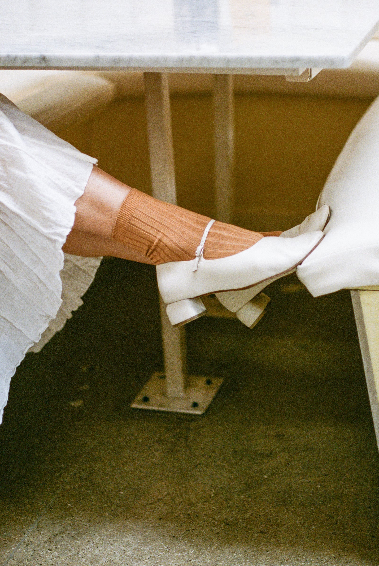 Model wears ribbed short socks in terracotta with off white mary jane..