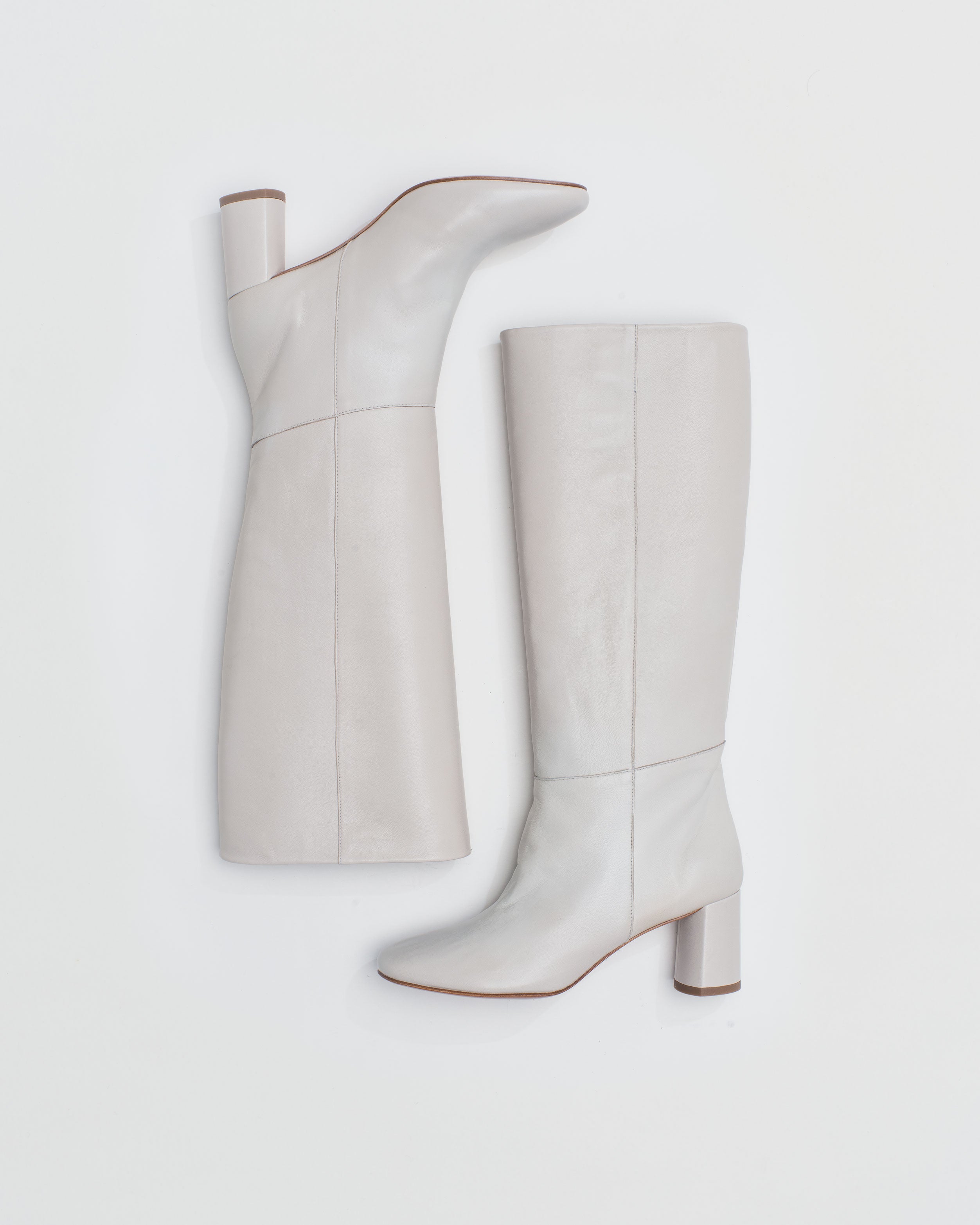 Tall pull-on boot in a supple cream, off-white leather that sits below the knee with a round toe