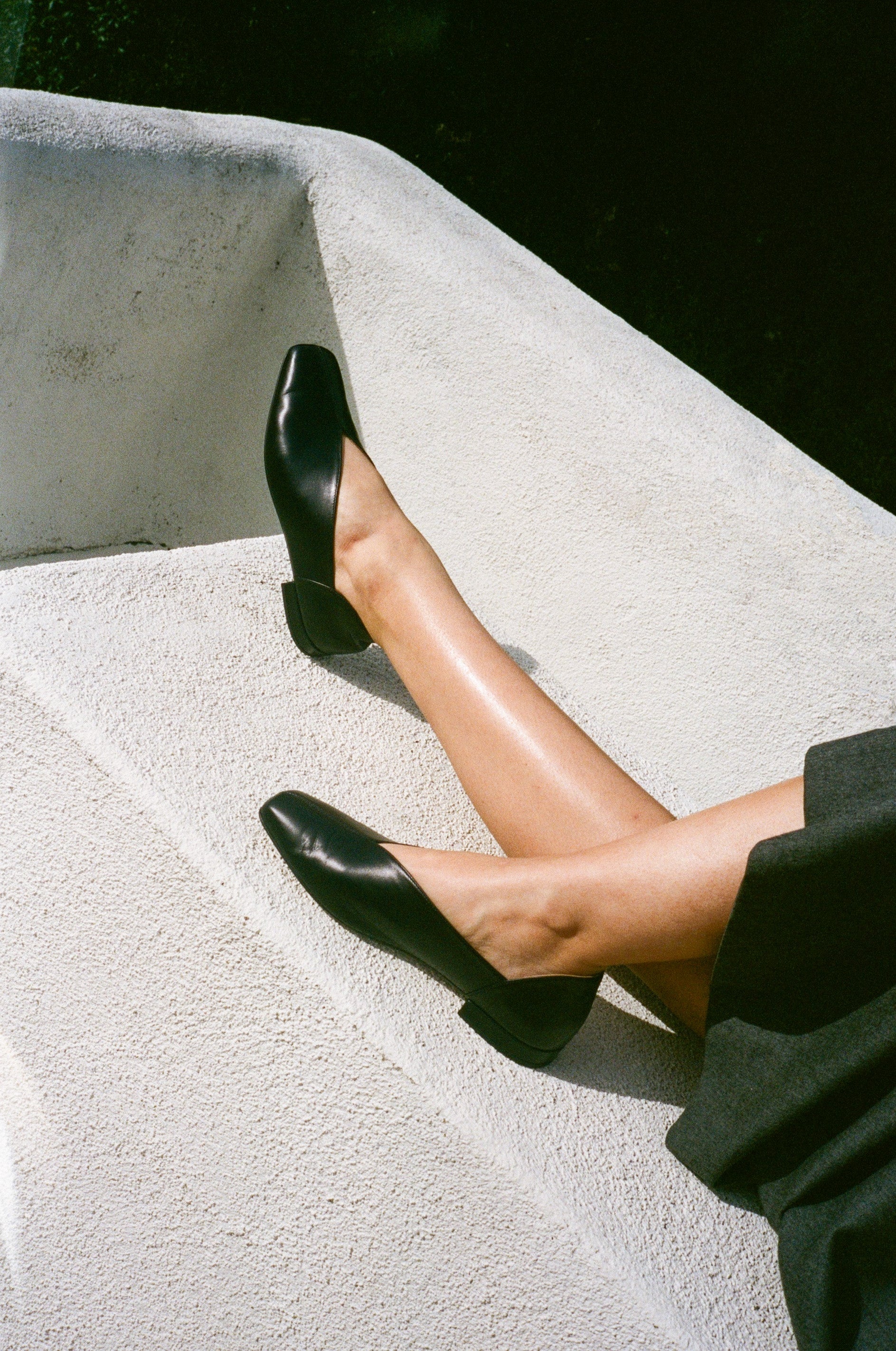 Model wears black leather flats with a tulip shaped upper.