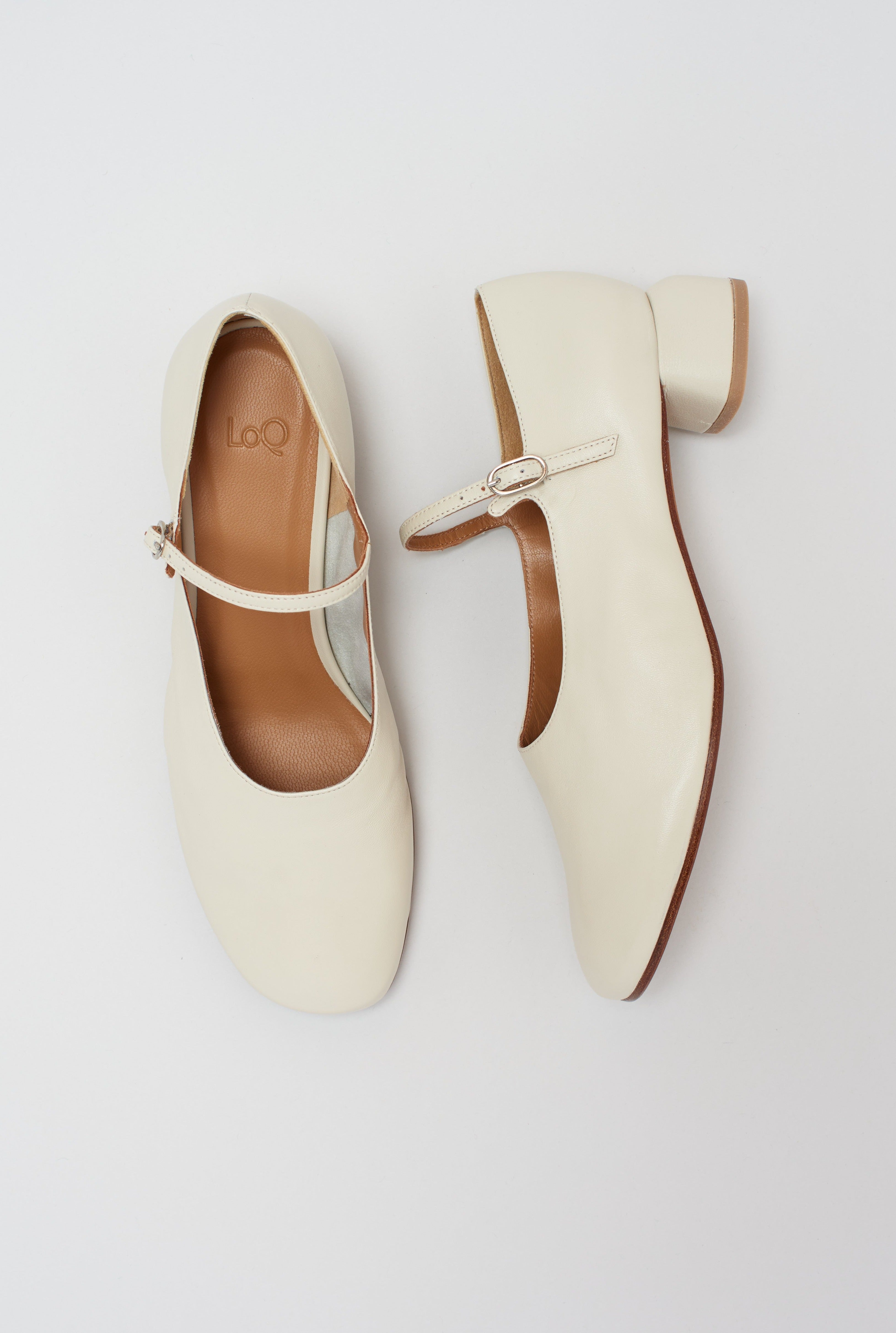 Modern Mary Jane featuring a classic silver buckle with an updated round heel in an off white leather. Round toe and 1" covered heel.