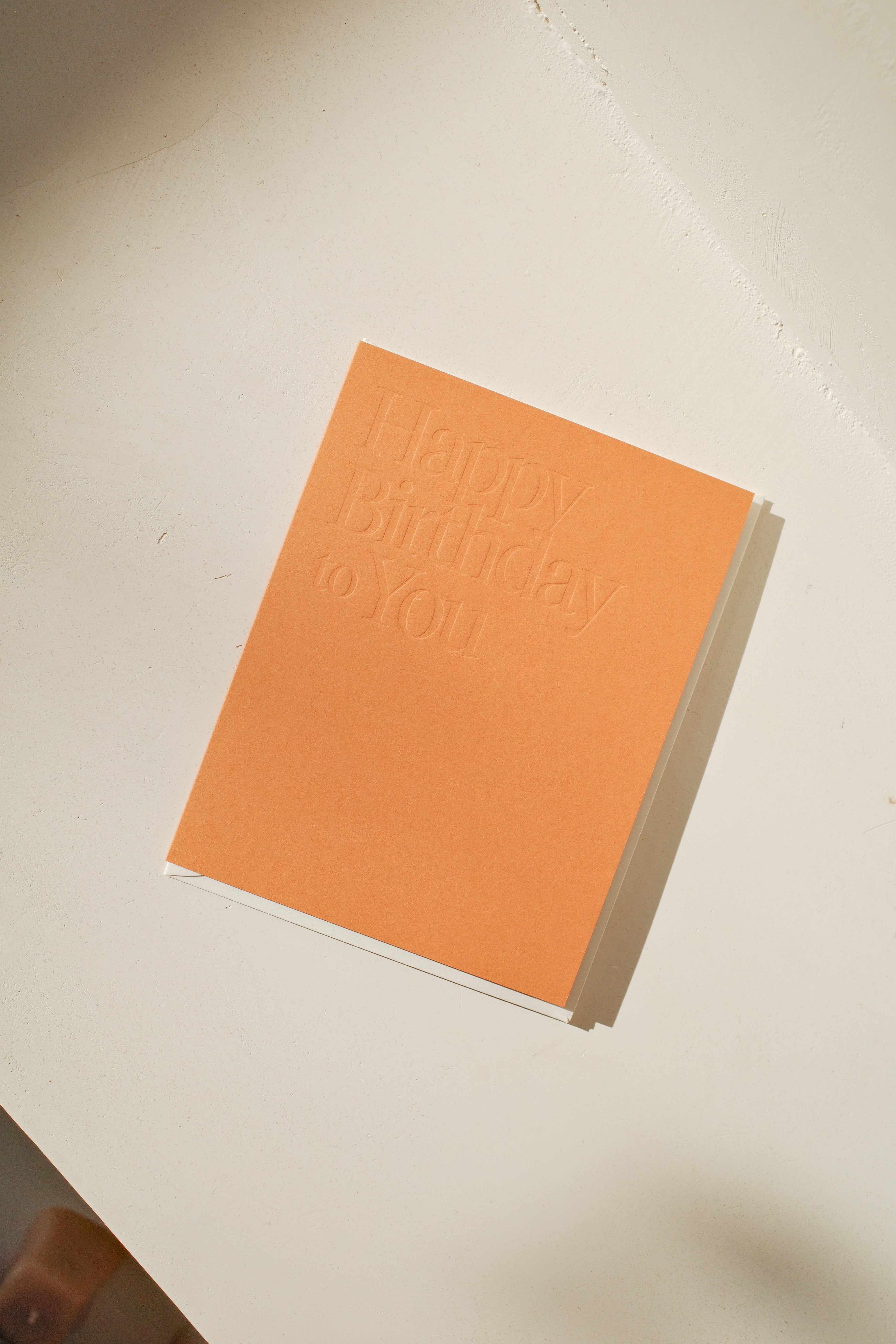 Orange greeting card with embossed "Happy Birthday to You" message.
