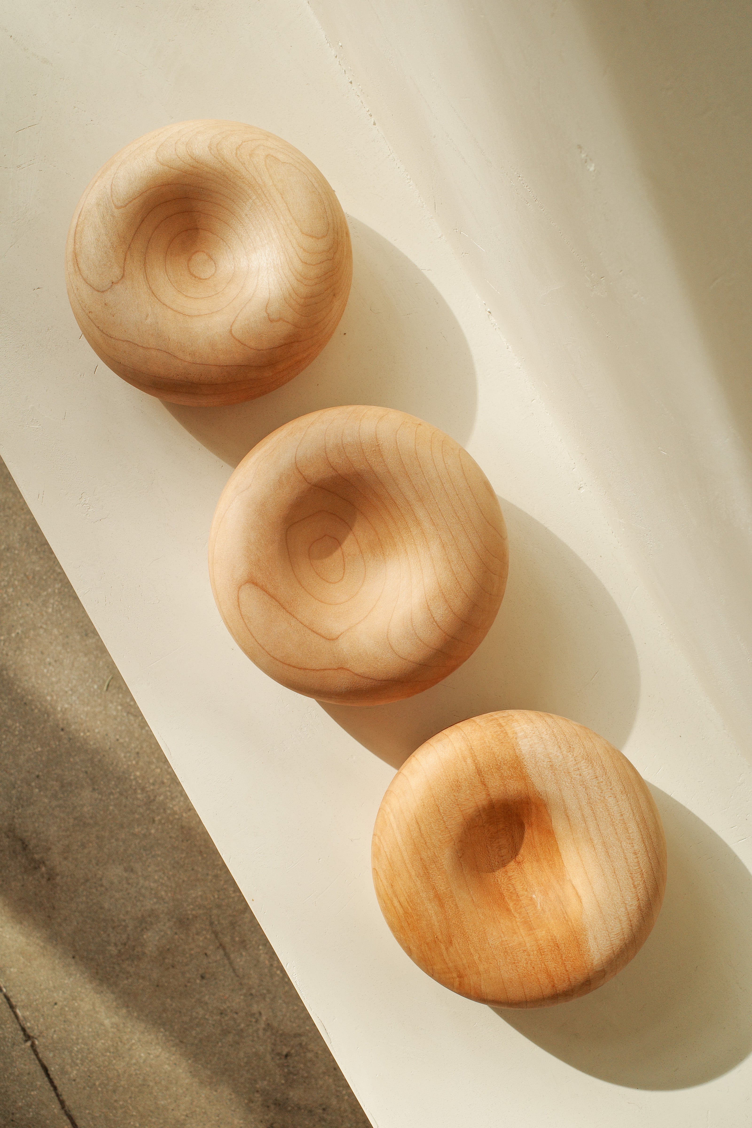 Sculptural donut shaped objects, hand turned with local maple wood.
