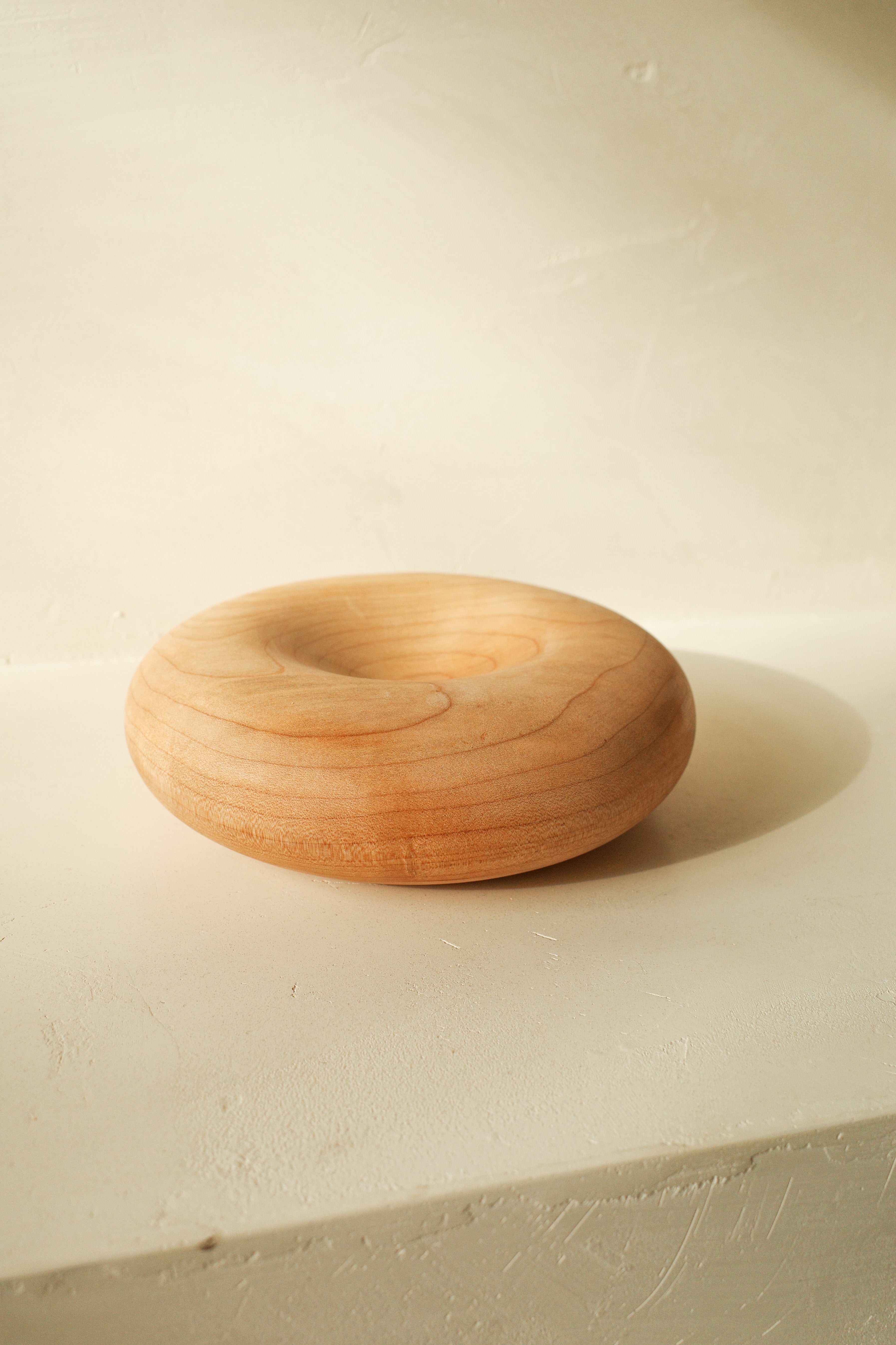 Sculptural donut shaped objects, hand turned with local maple wood.