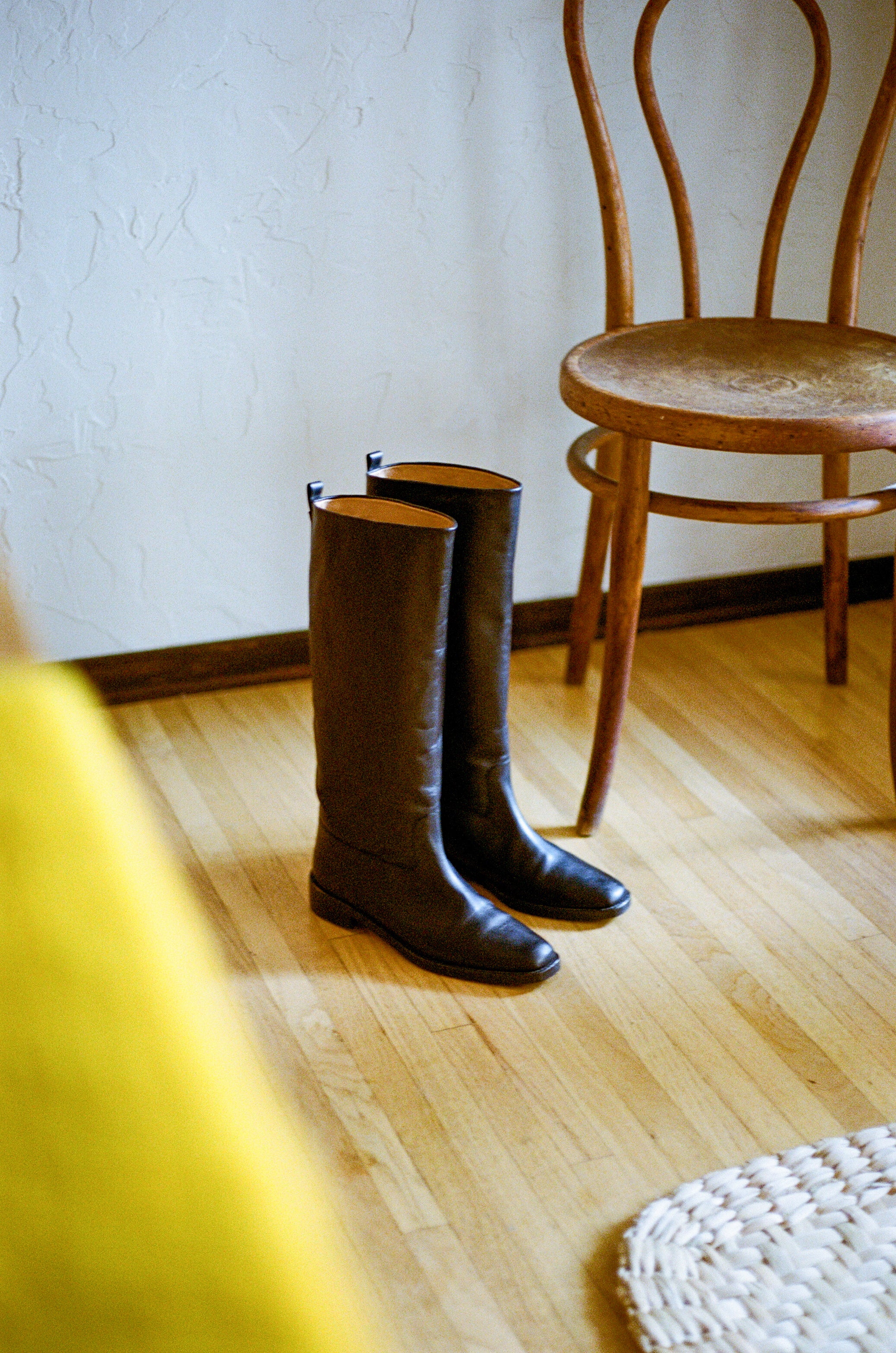 Tall black riding boot with almond shaped toe.
