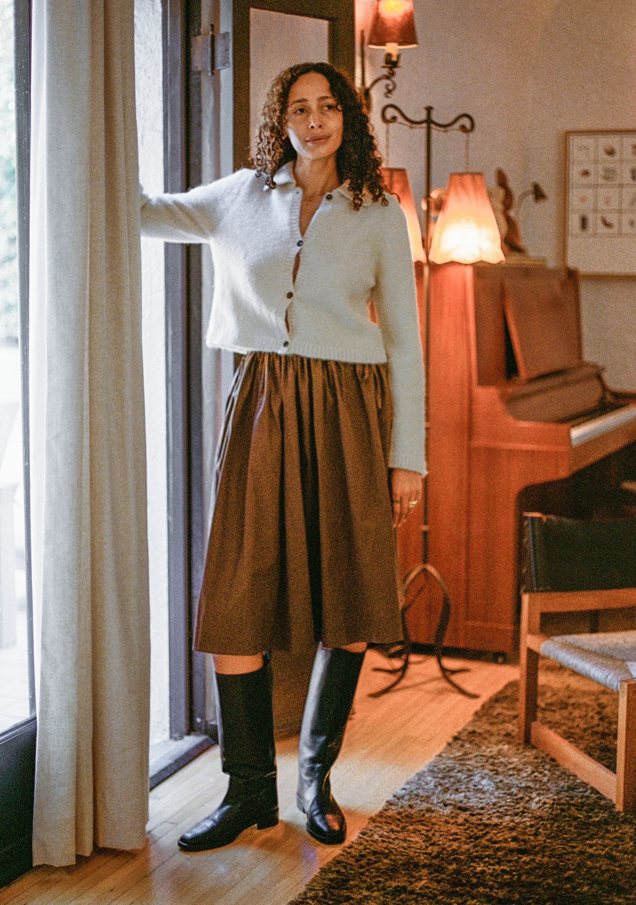Model wears tall black riding boot with almond shaped toe.