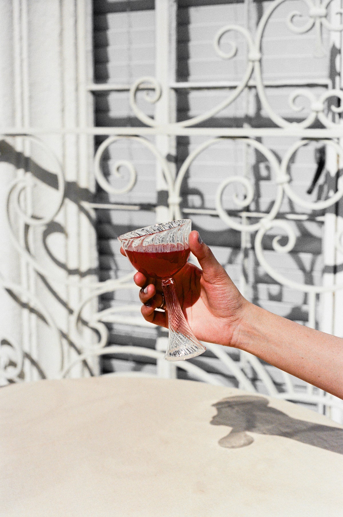 Model holds ribbed champagne coupe.
