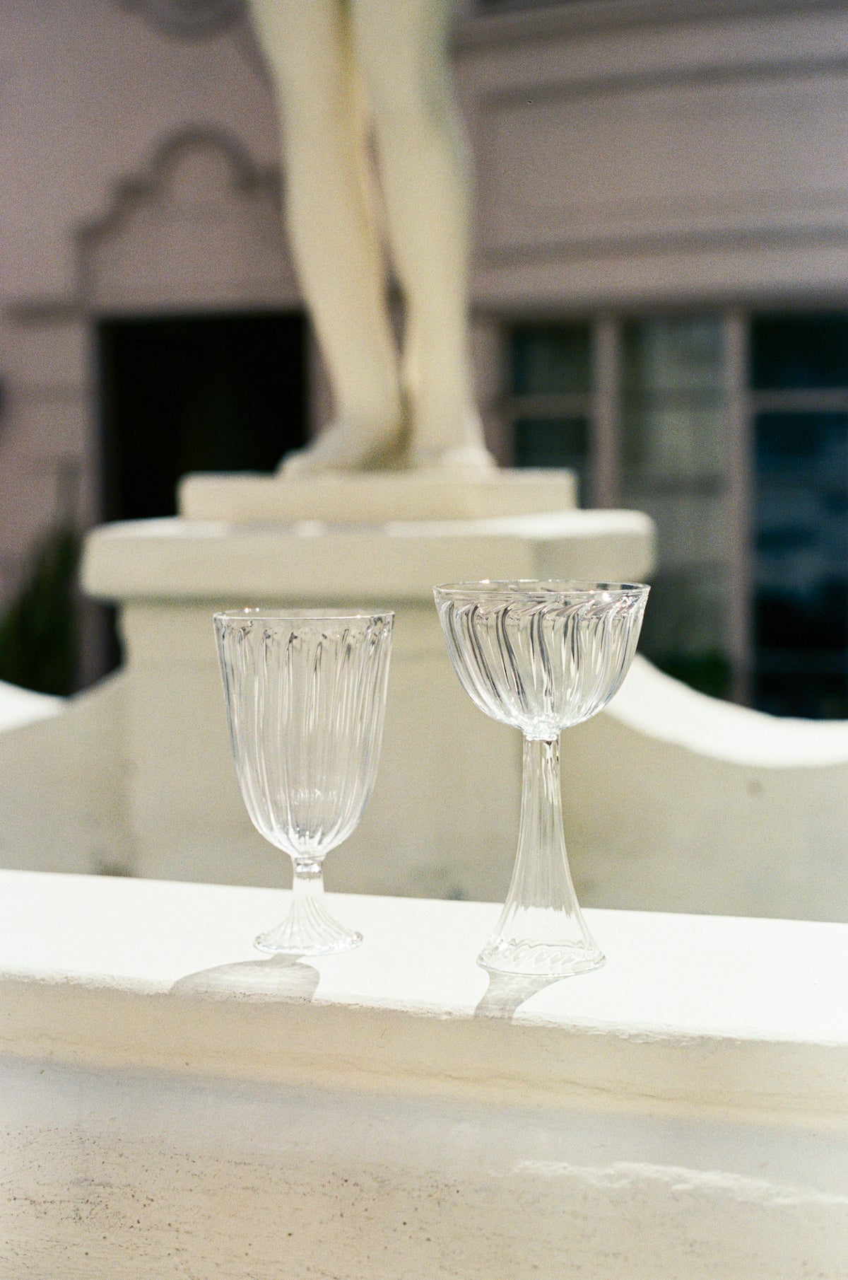 Ribbed wine glass next to ribbed champagne coupe.