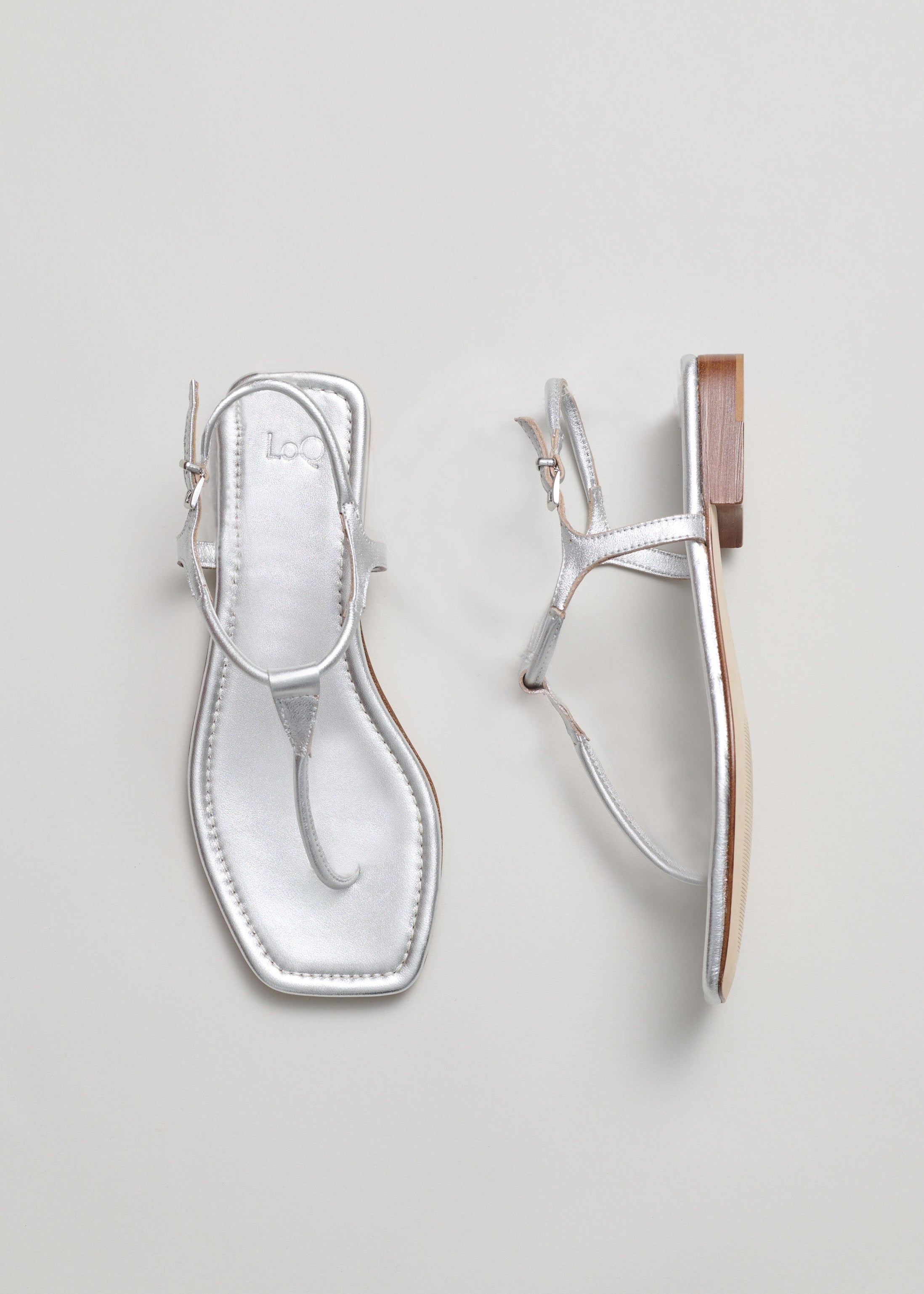 Silver sandal with a strap on a light gray background
