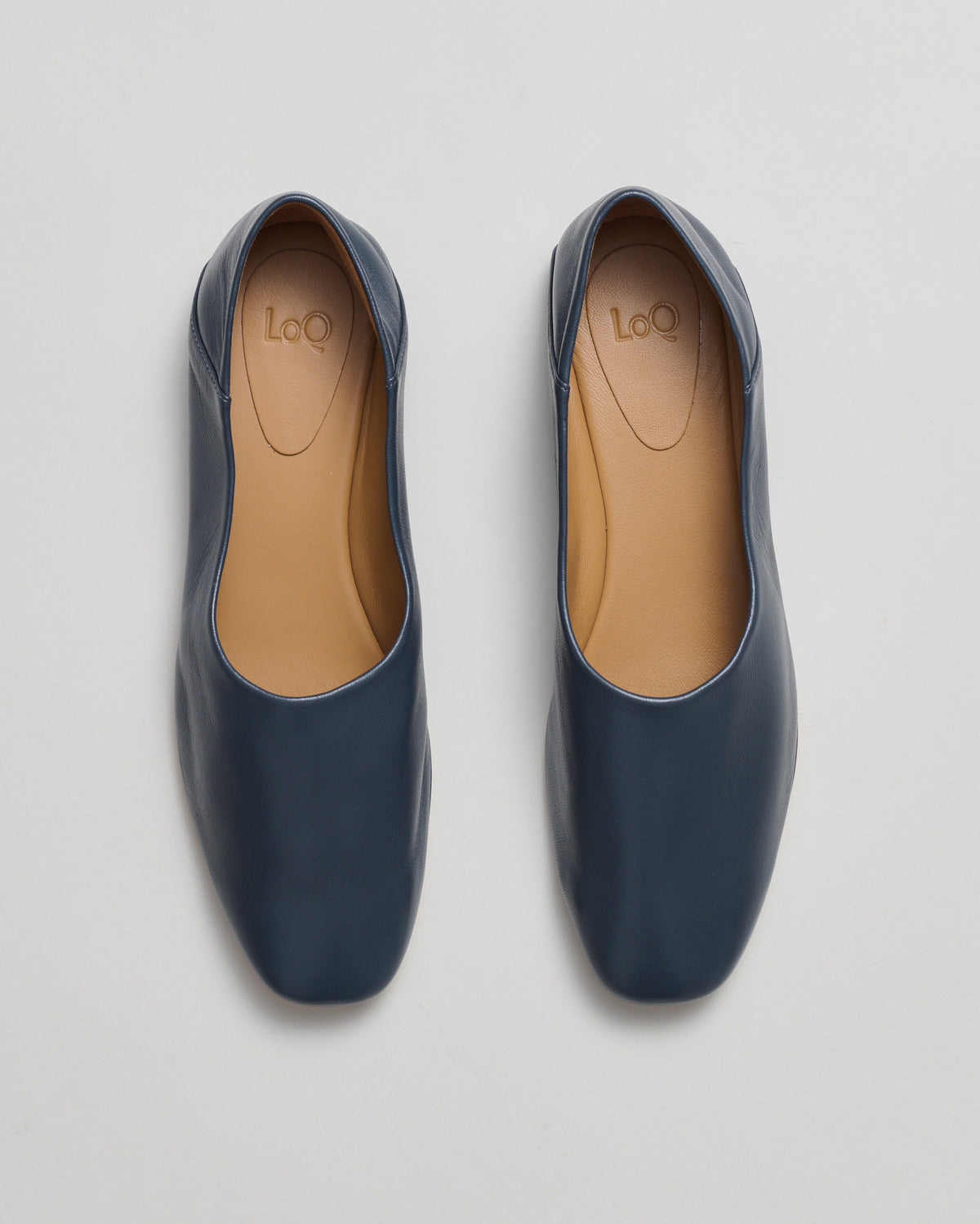 A pair of everyday flat shoe with a collapsable back featuring a square toe in a soft petrol blue leather.