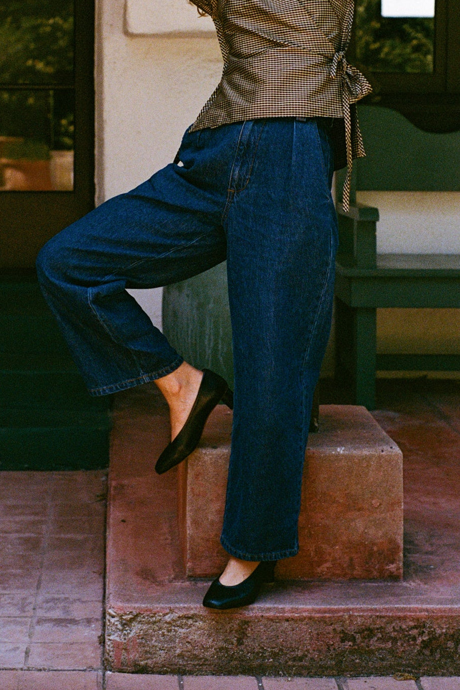 Model wears black leather pump with sculptural oval heel and center seam.