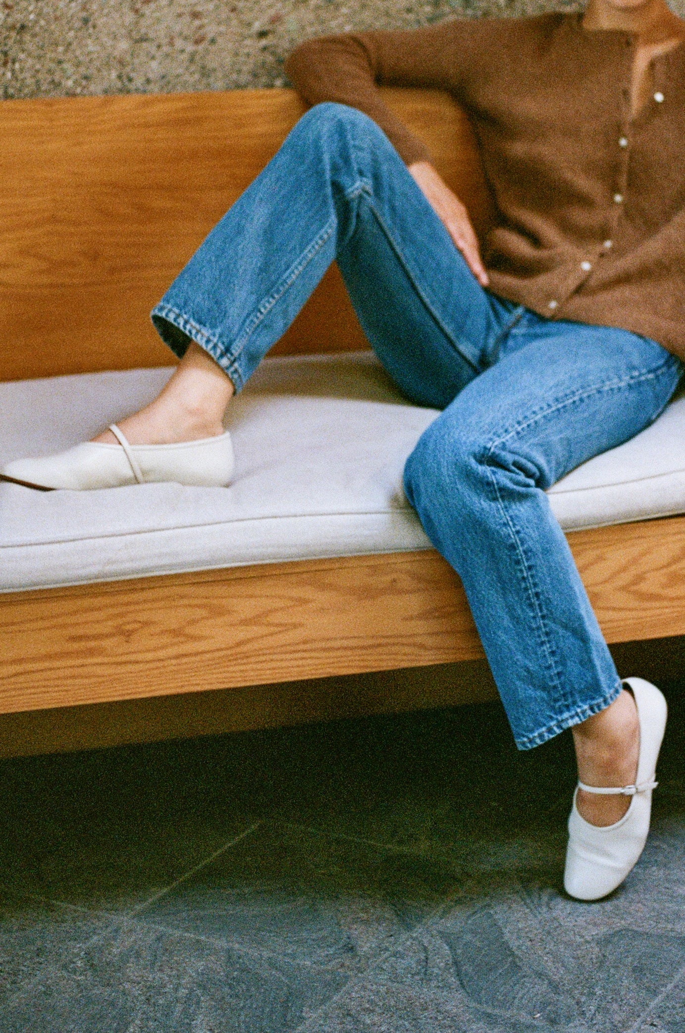 Model wears off white colored leather mary jane style flat shoe with strap and buckle closure.