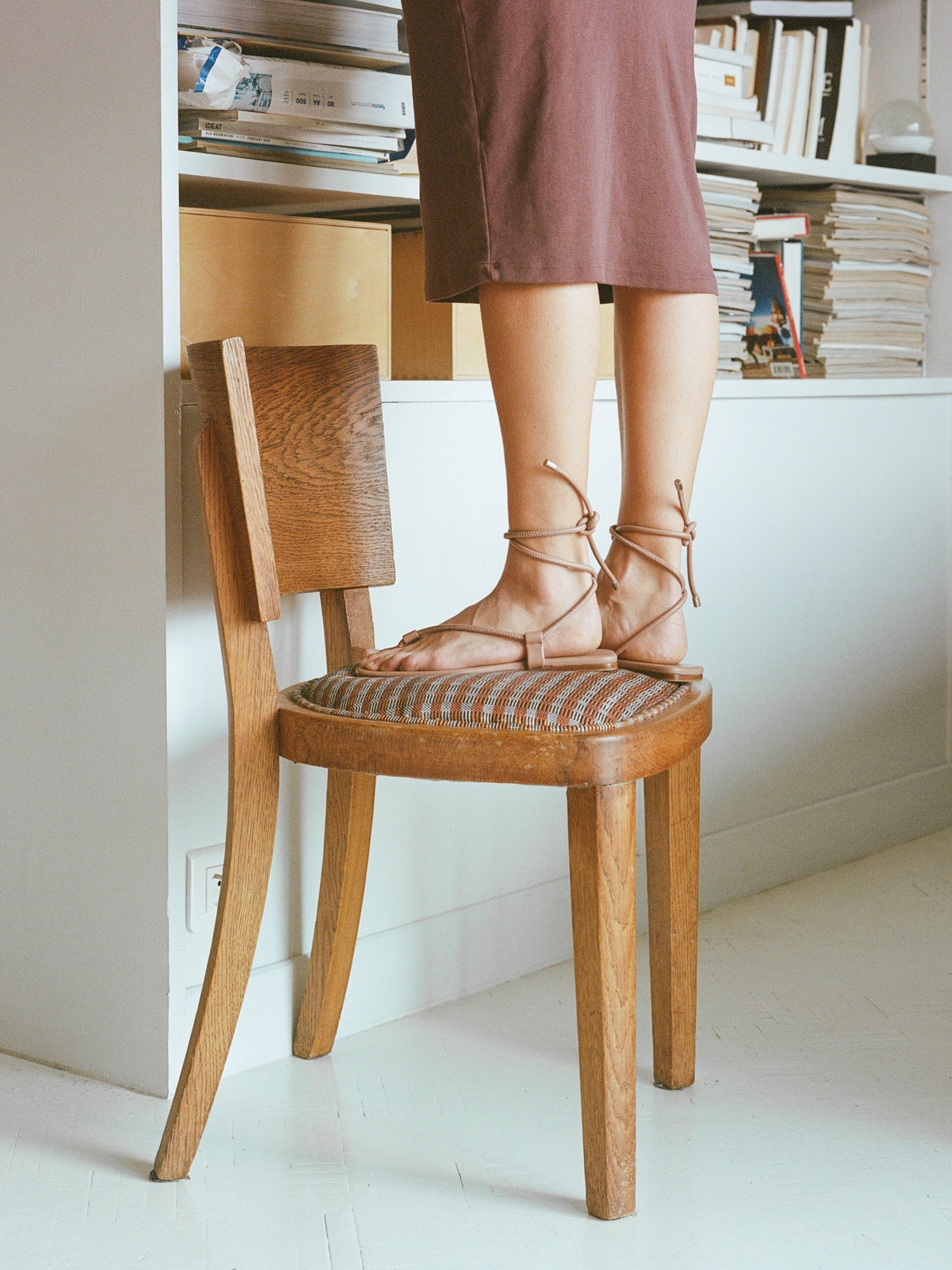 Model wears tan colored ankle wrap sandals.