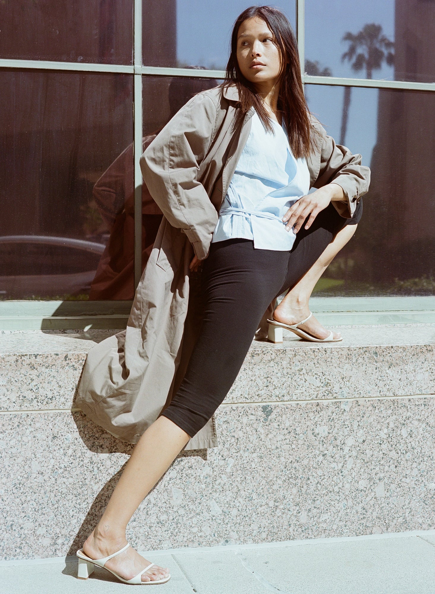 Model wears off white heeled leather sandal featuring two thin straps and square block heel.