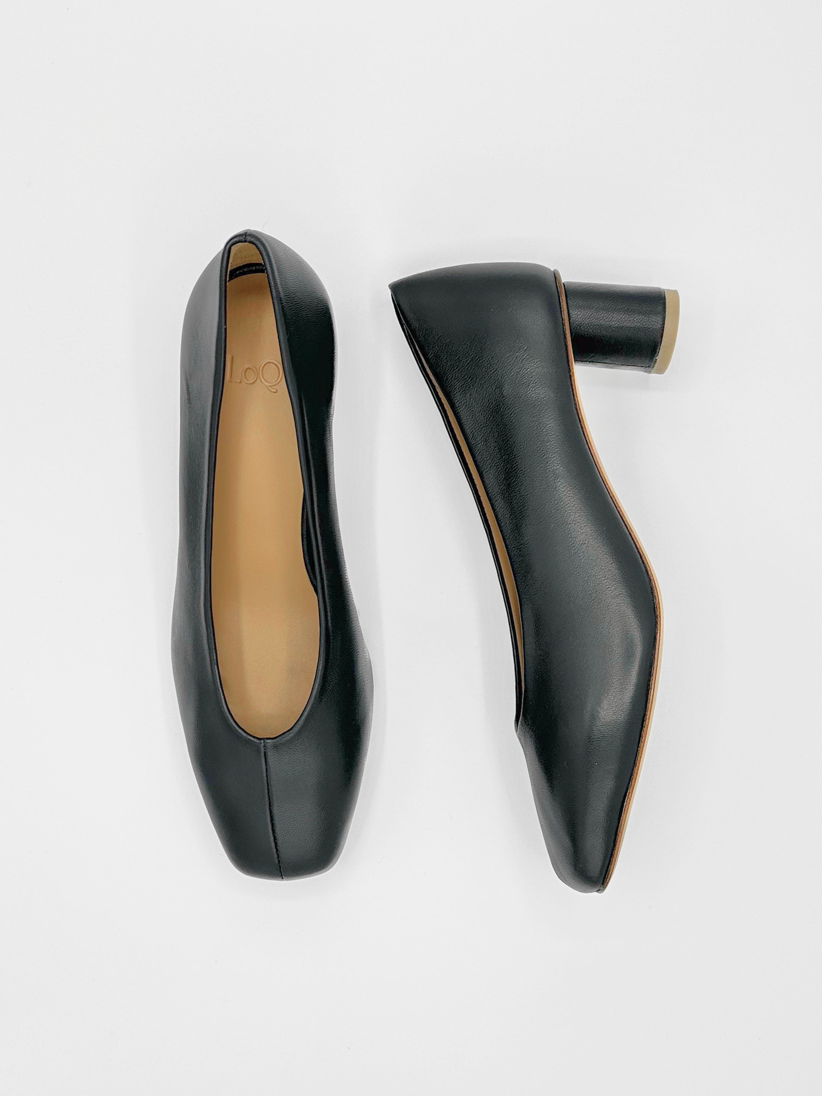 black leather pump with sculptural oval heel and center seam.