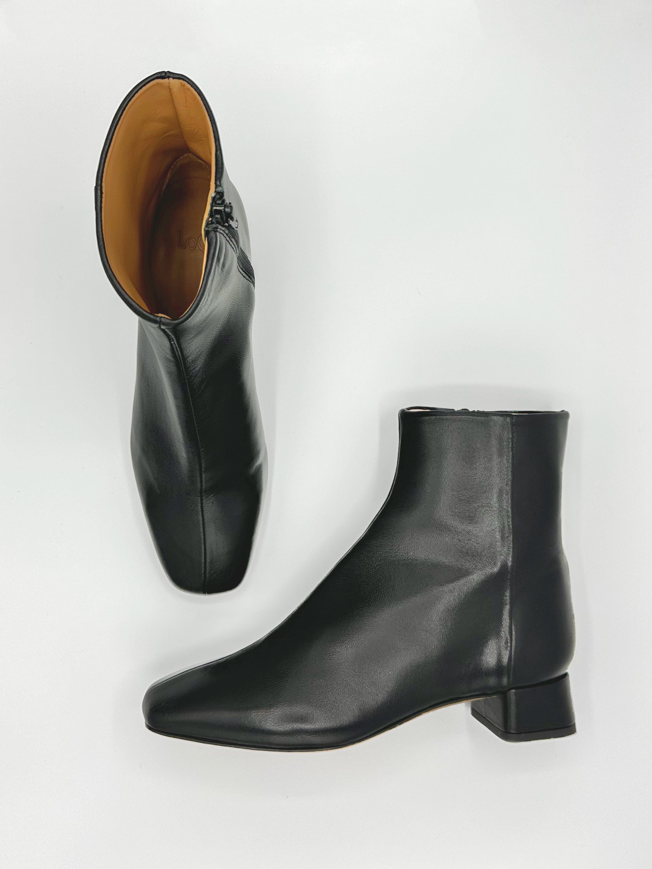 black ankle boot with square toe and heel, center seam and side zipper.
