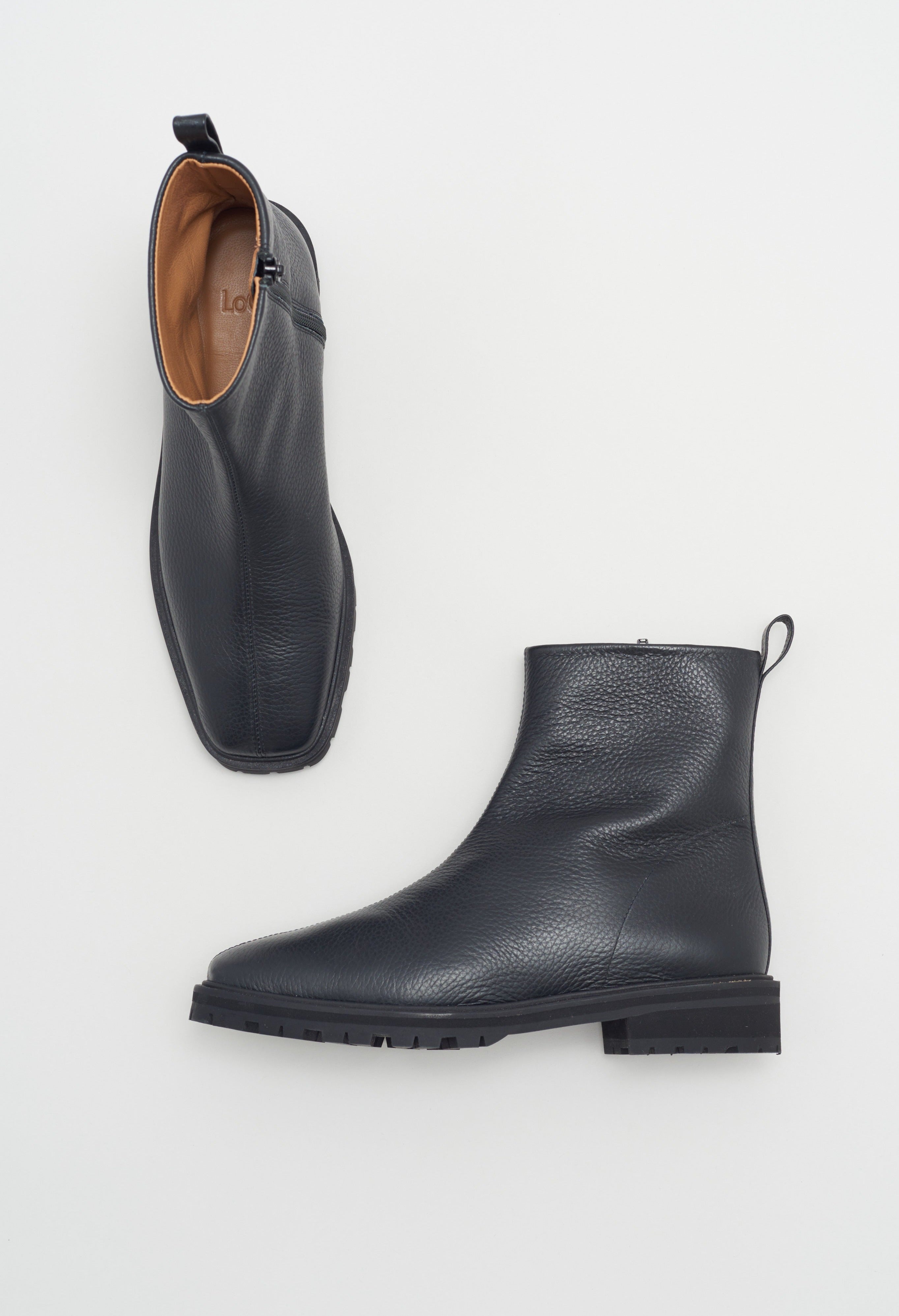 Black tumble leather ankle boot with rubber tread sole and side zipper.