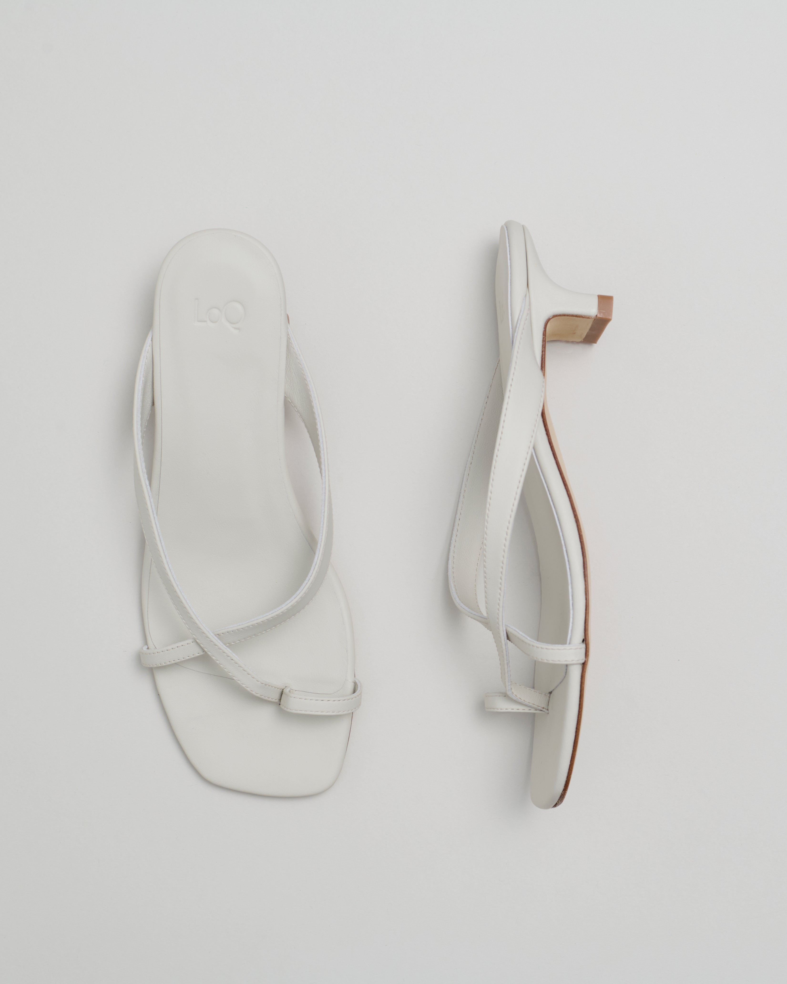 Pair of off white sandals on a light gray background
