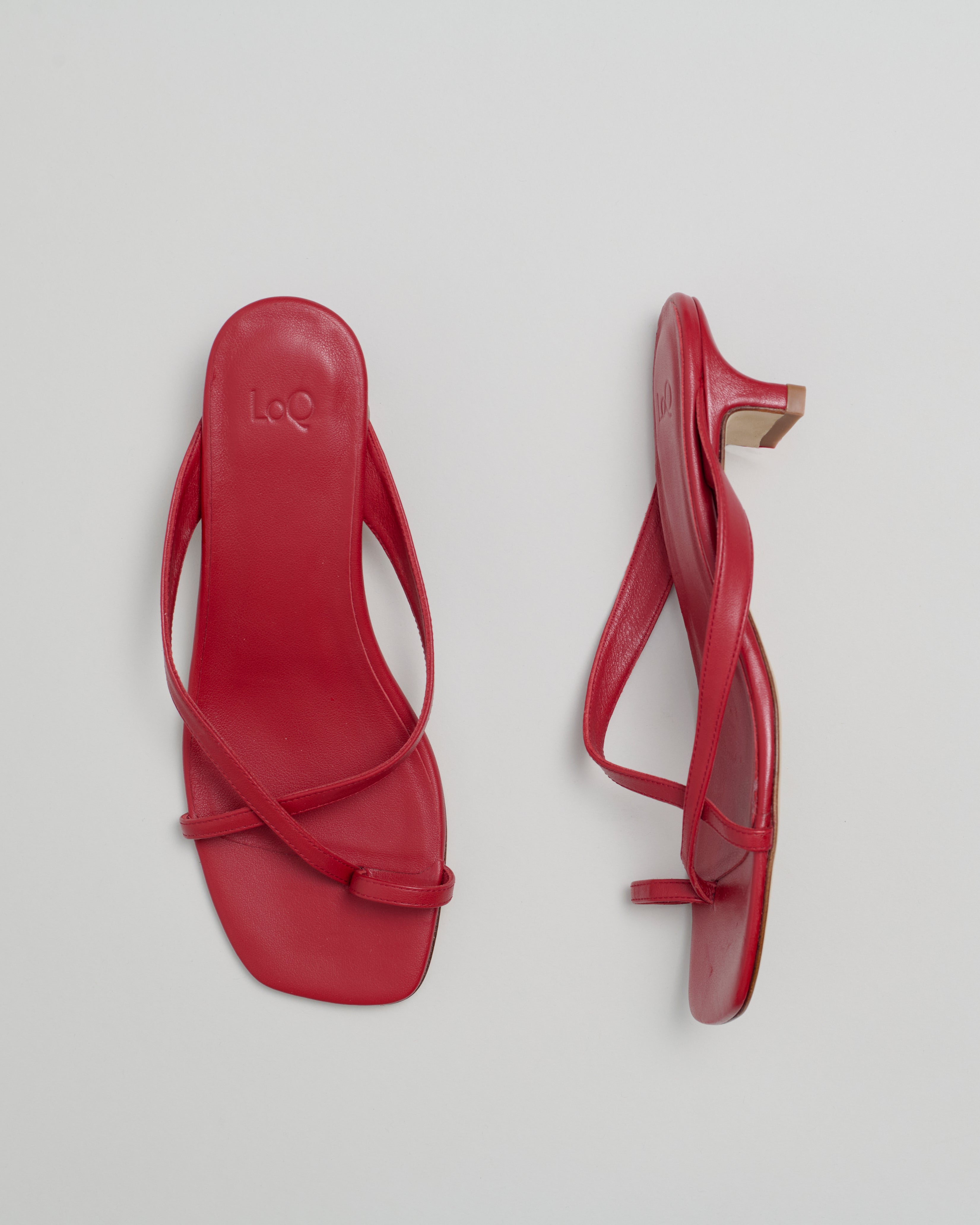 Red strappy sandals on a light gray background