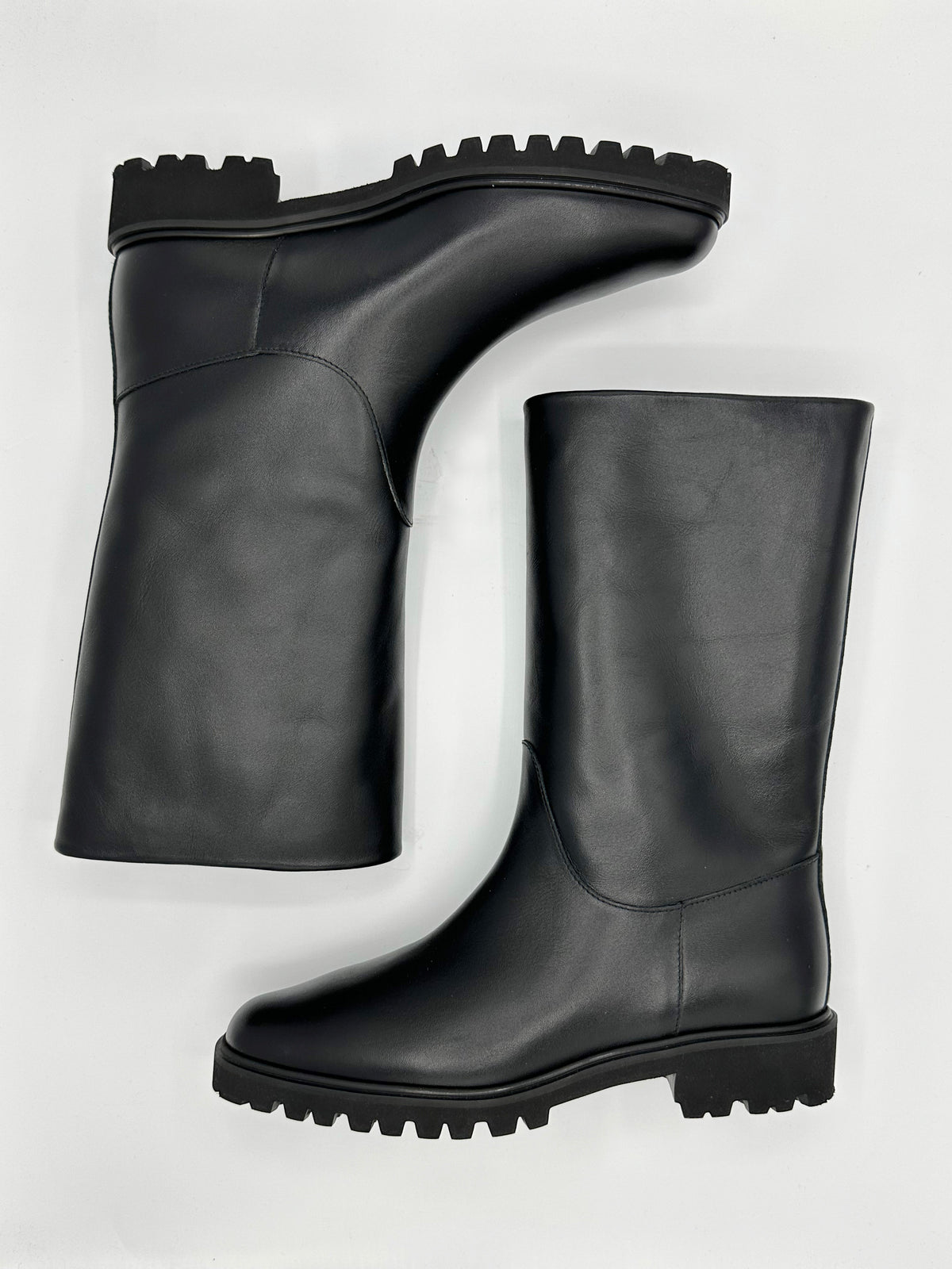 A pair of black leather mid calf boot
