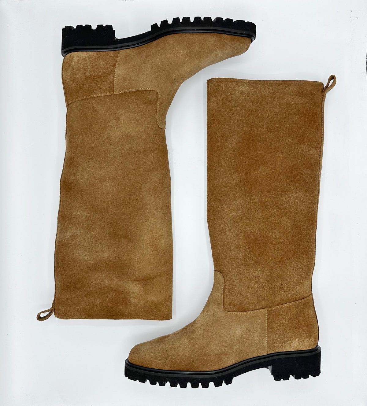 A pair of tall knee-high suede boots in a warm tan-brown color, featuring black lug soles.