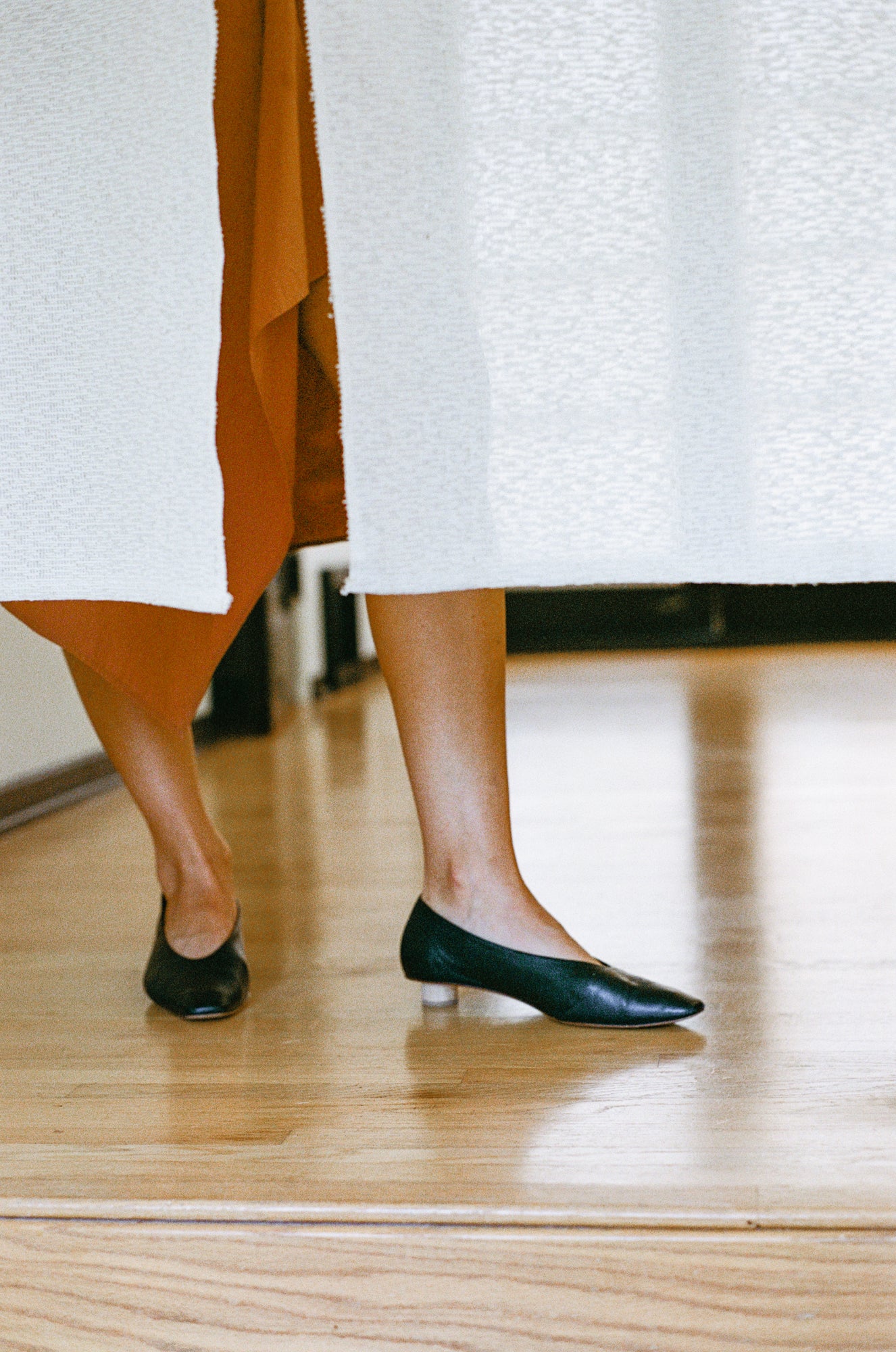 Ballet flat with a squared-off almond toe in smooth black leather. Glove-like fit. Mini ¾" cylinder beechwood heel.