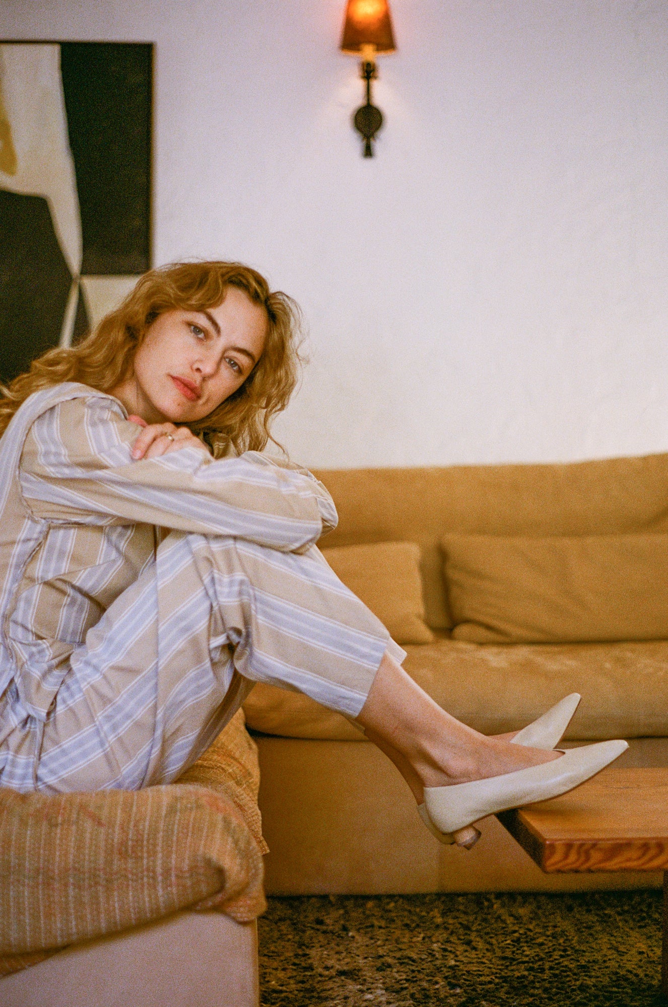 Model wears light tan colored leather ballet flat with short, cylindrical wood heel.