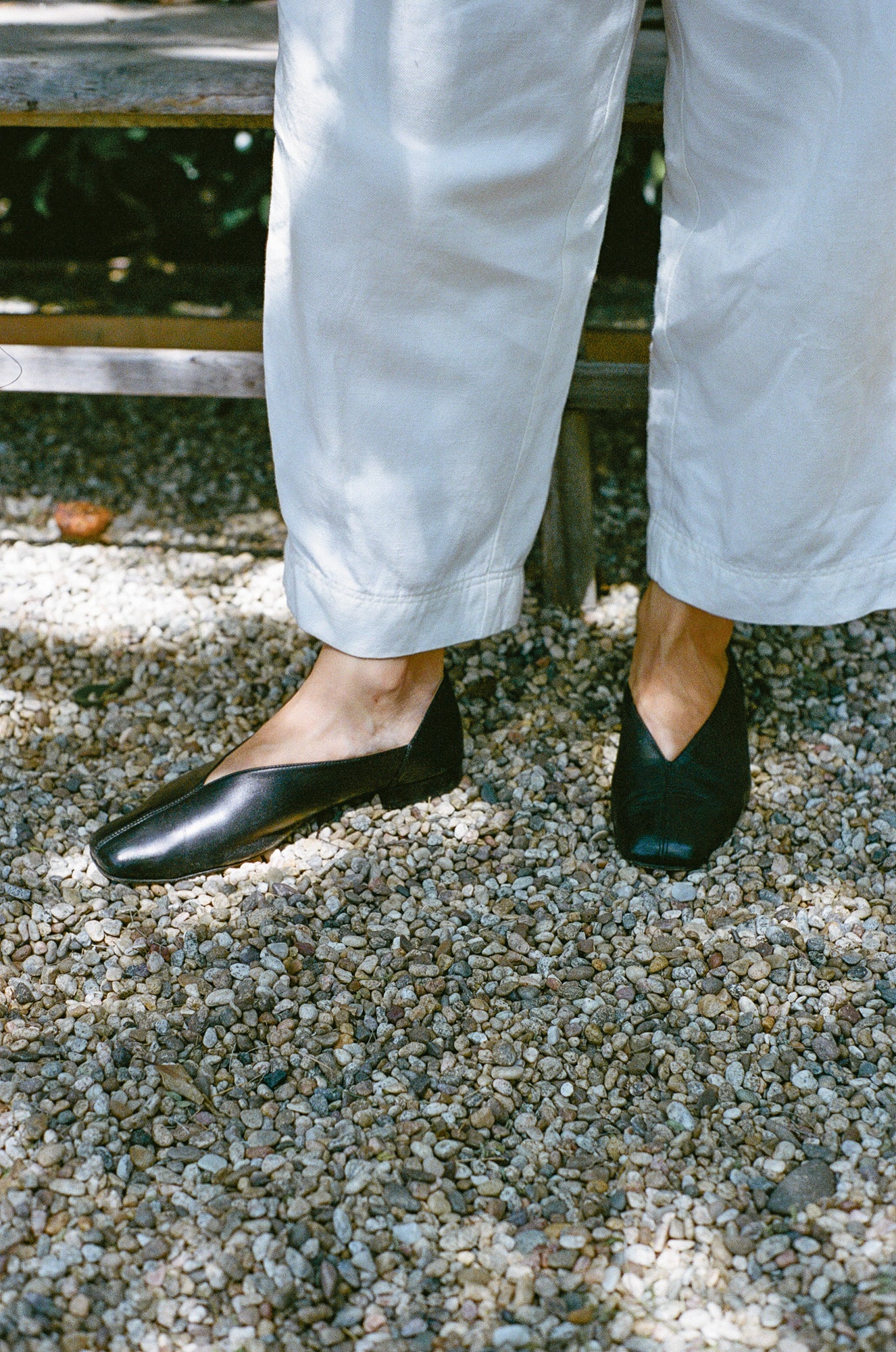 Model wears black leather flats with a tulip shaped upper.