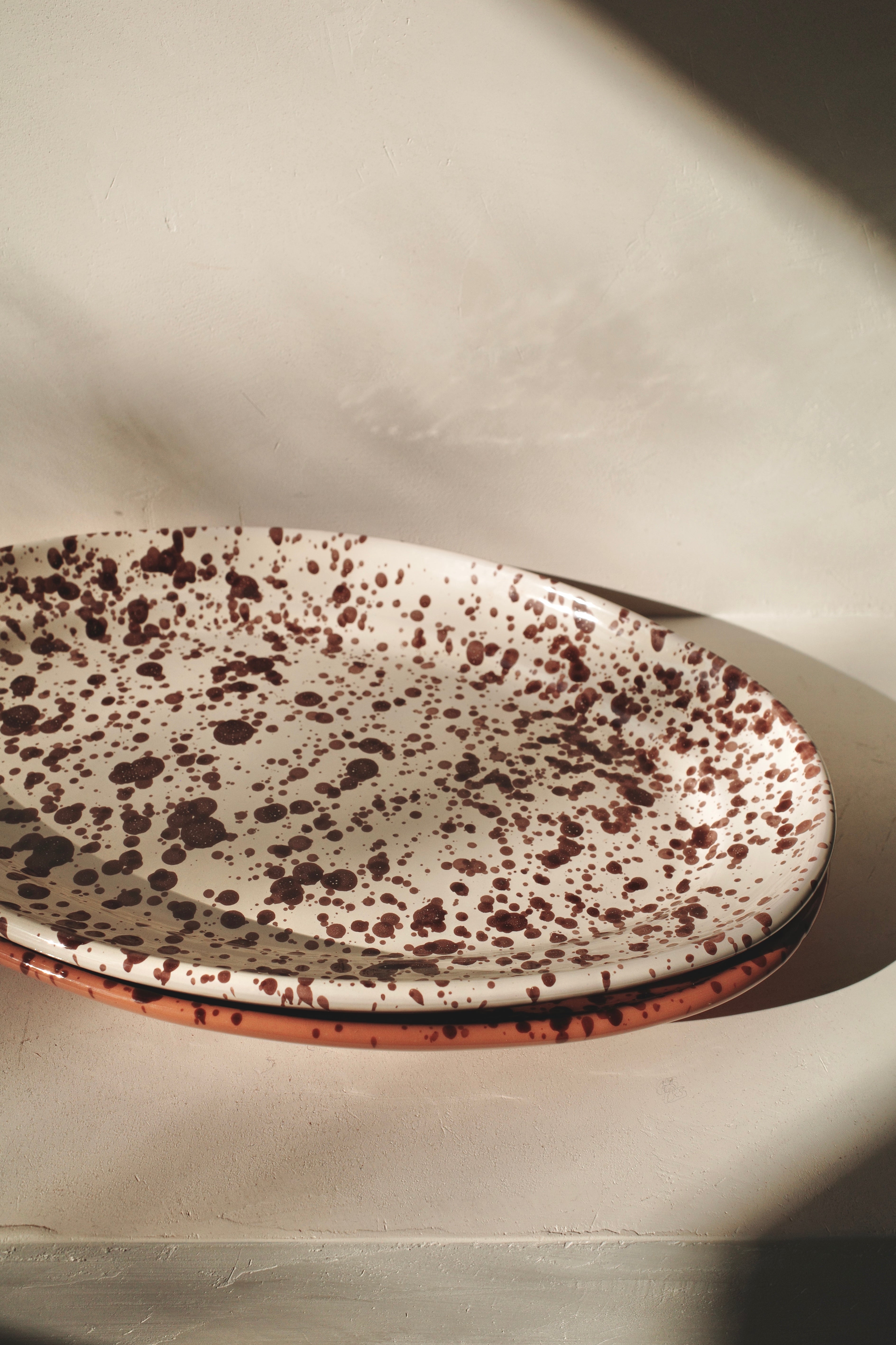 Stack of ceramic platters with different glaze patterns.