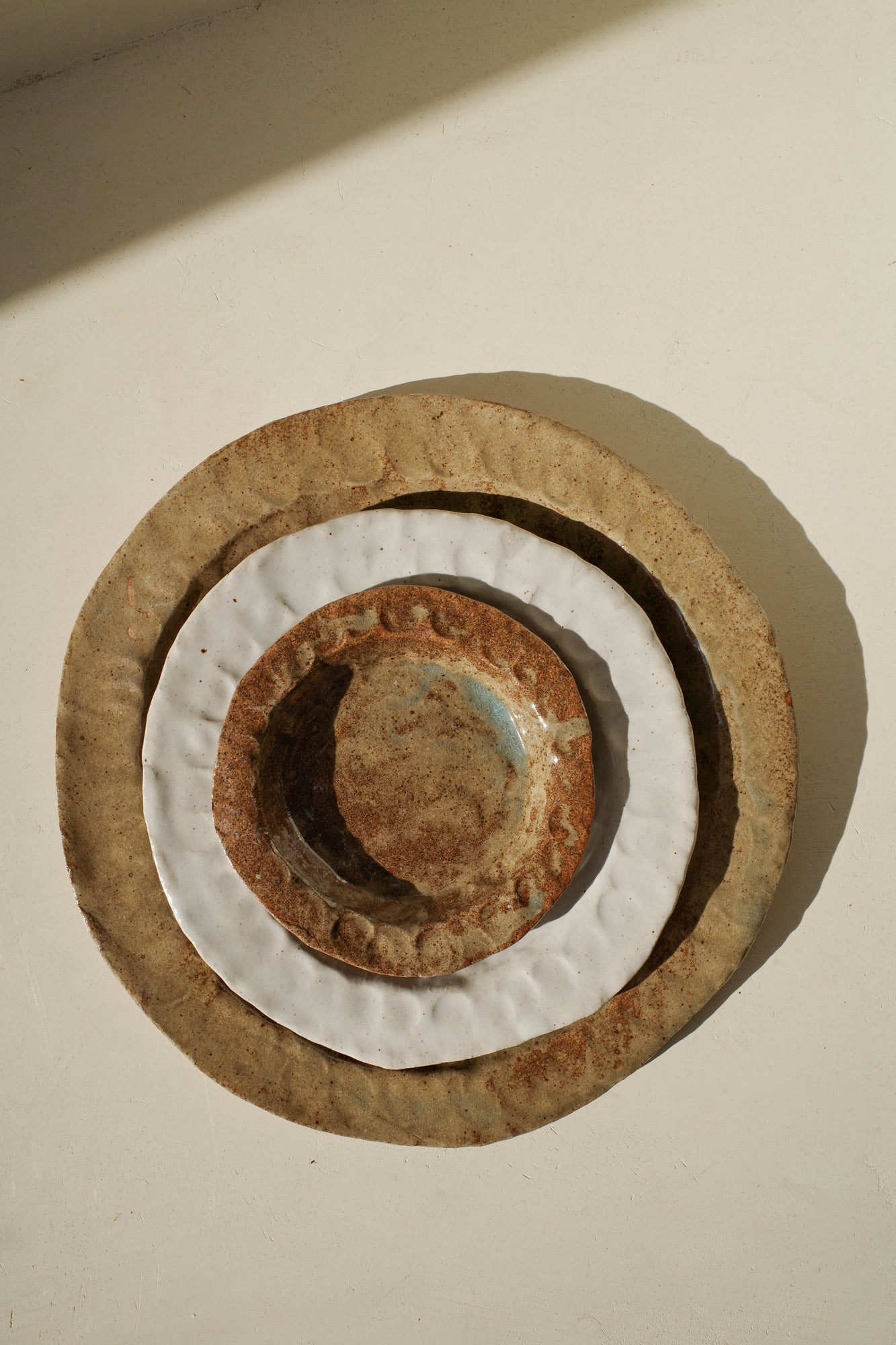 Handmade ceramic plates in varying sizes and glazes.